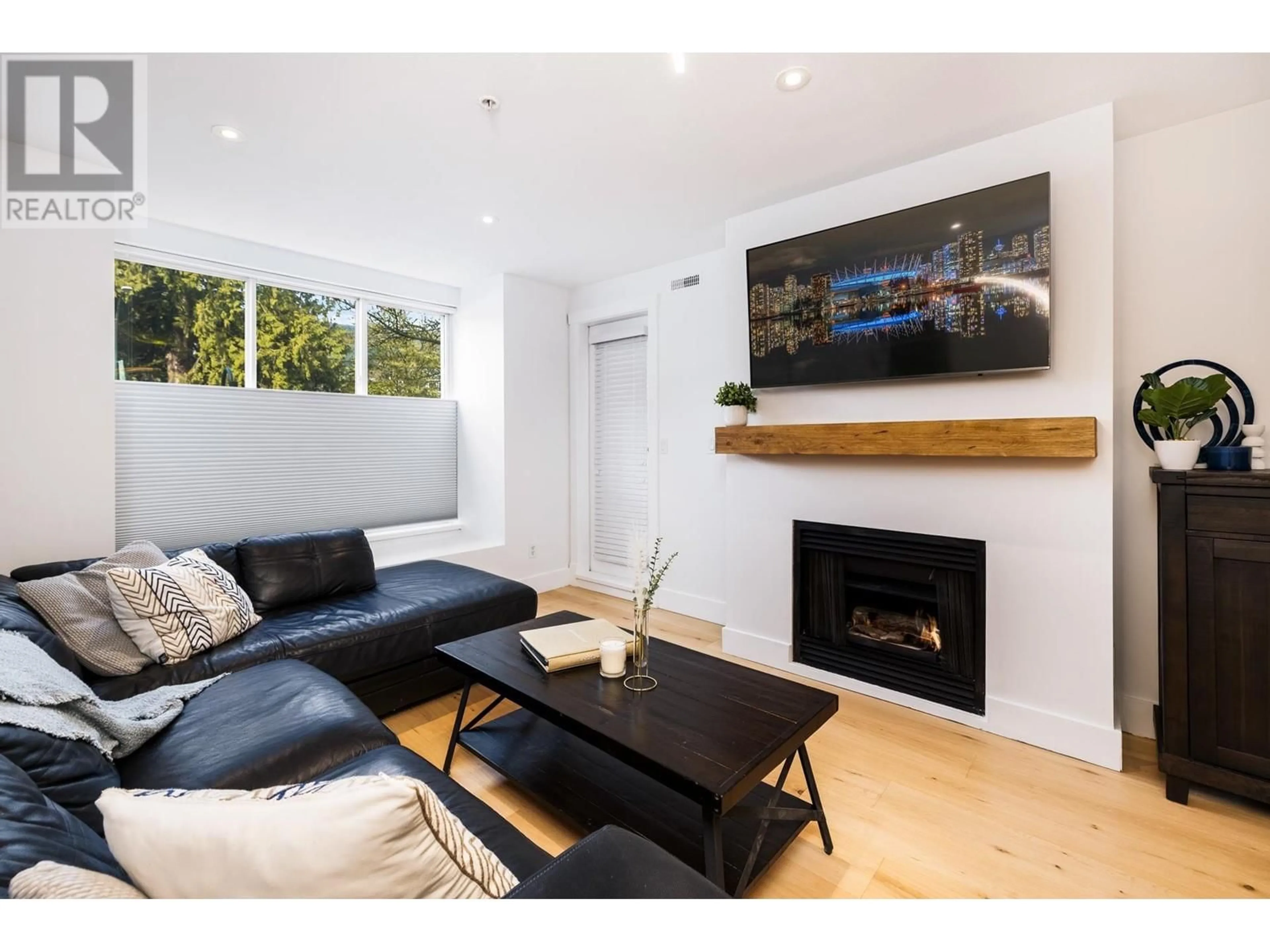 Living room with furniture, wood/laminate floor for 204 - 1111 LYNN VALLEY ROAD, North Vancouver British Columbia V7J3V4