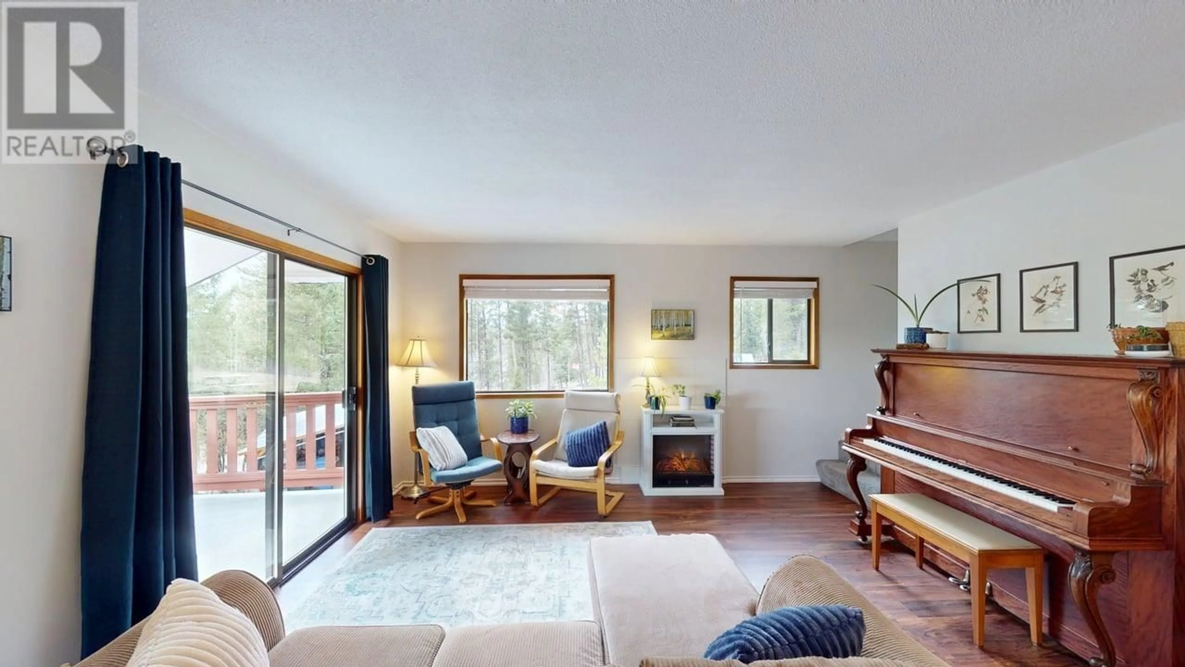 Living room with furniture, wood/laminate floor for 4917 KITWANGA DRIVE, 108 Mile Ranch British Columbia V0K2Z0