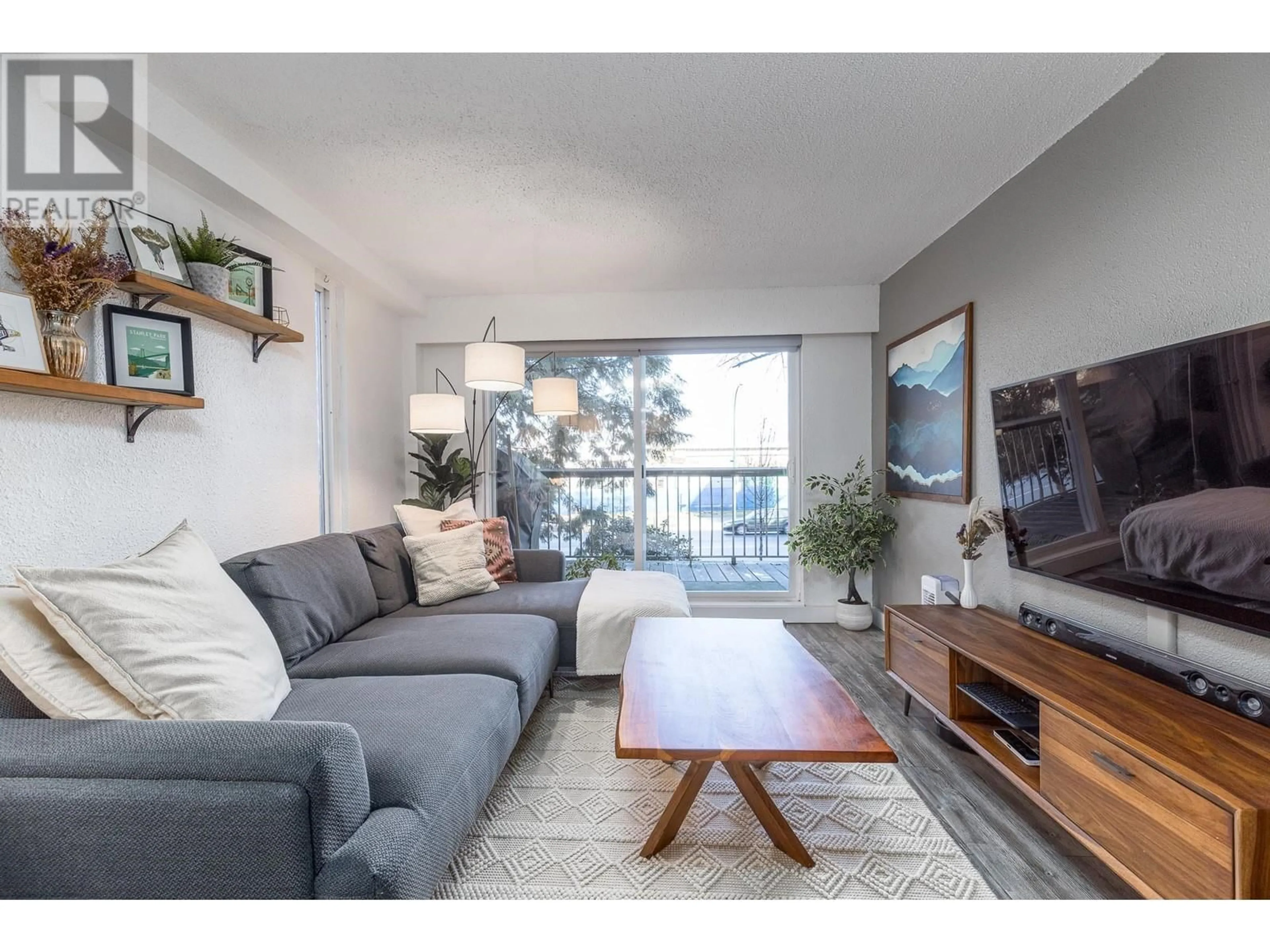 Living room with furniture, wood/laminate floor for 201 - 756 GREAT NORTHERN WAY, Vancouver British Columbia V5T1E4
