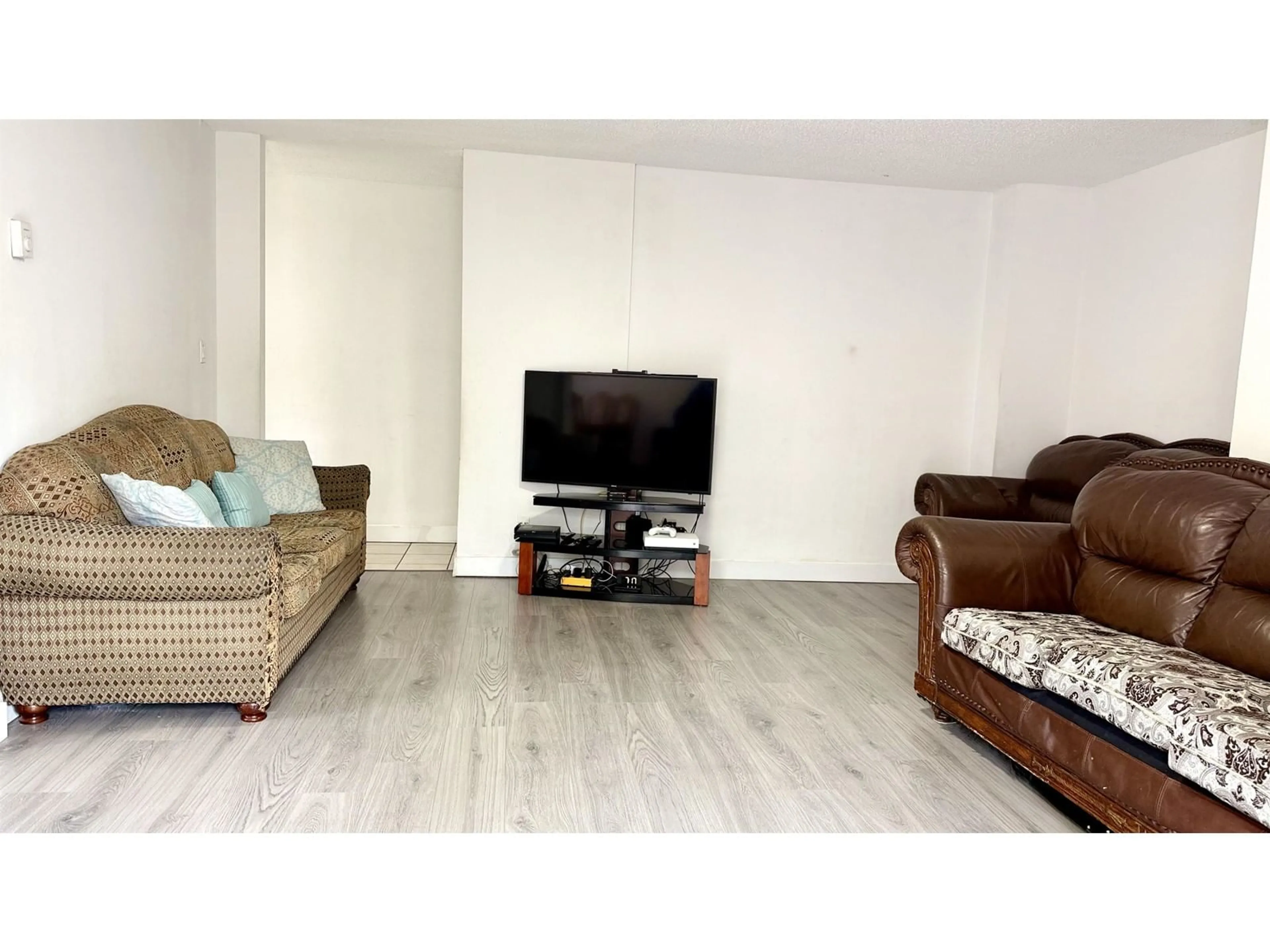 Living room with furniture, wood/laminate floor for 101 - 7131 133A, Surrey British Columbia V3W8A1