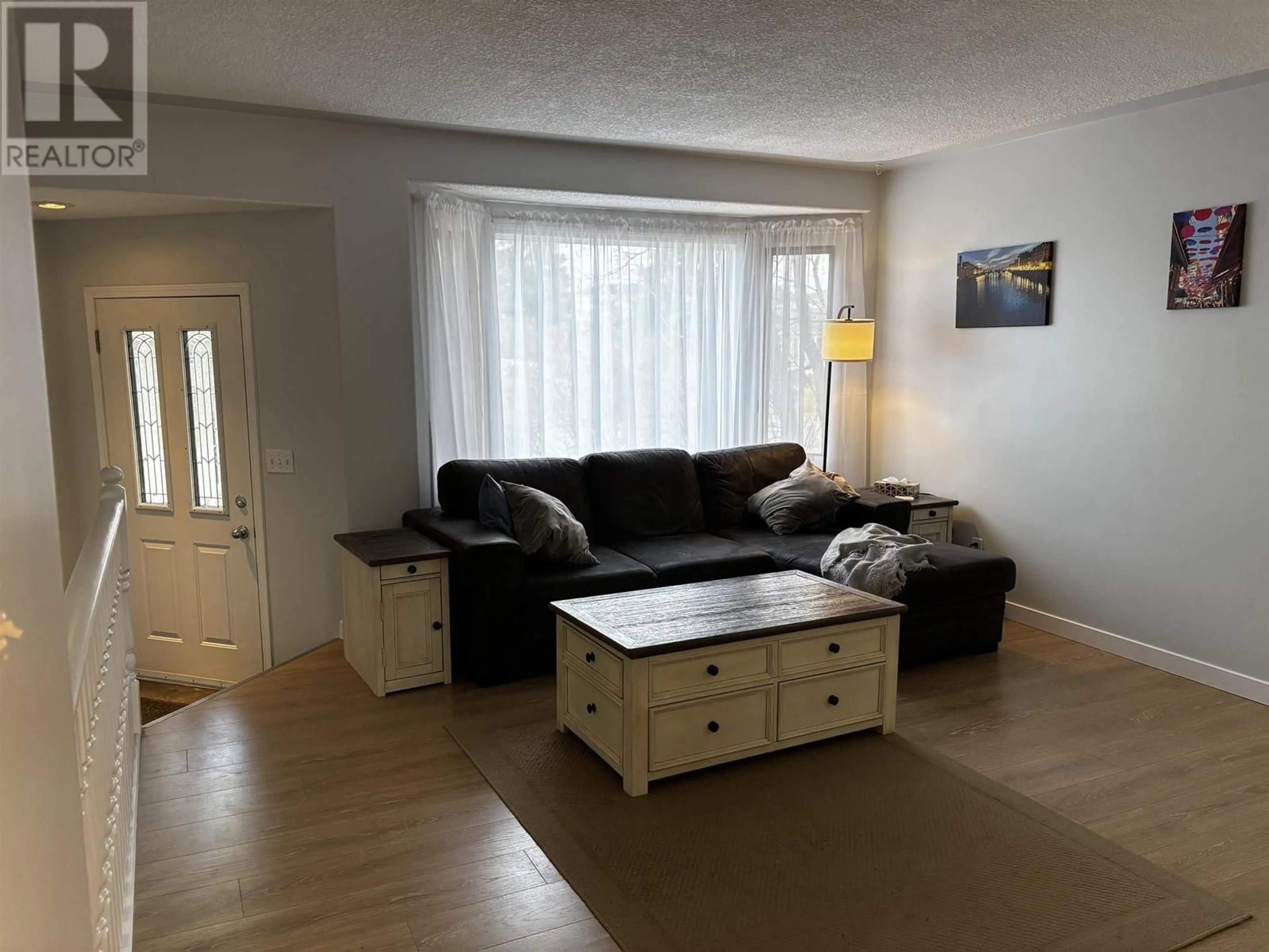 Living room with furniture, wood/laminate floor for 9011 99 AVENUE, Fort St. John British Columbia V1J5S2