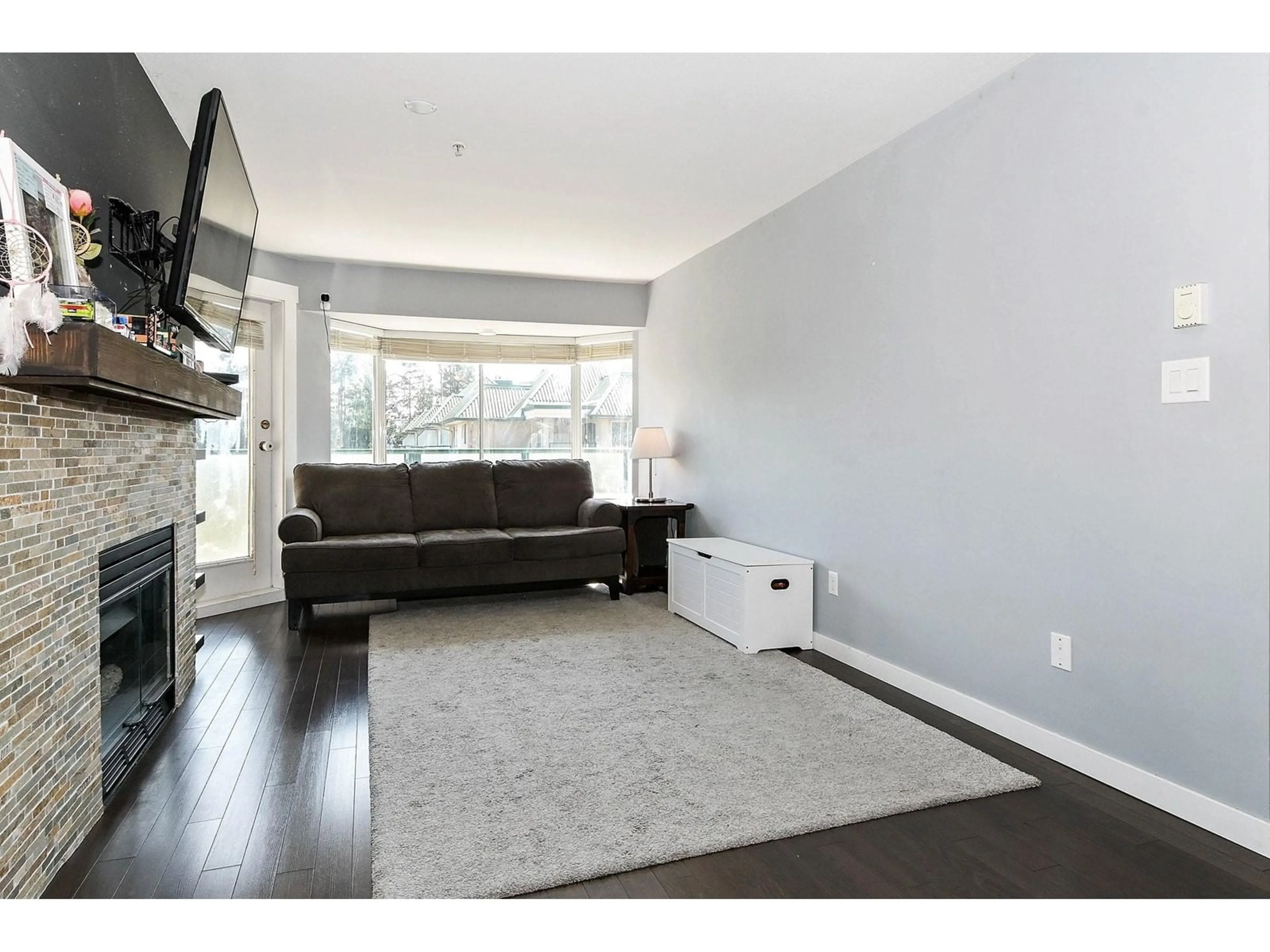 Living room with furniture, wood/laminate floor for 404 - 2962 TRETHEWEY, Abbotsford British Columbia V2T4M3