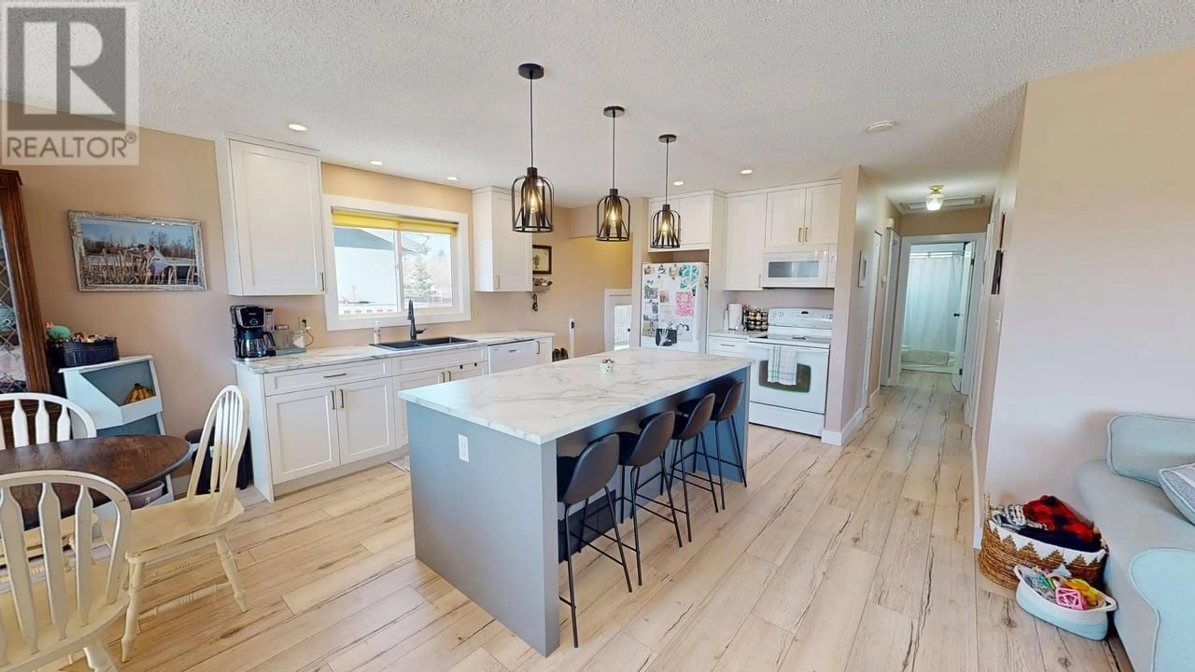 Open concept kitchen, wood/laminate floor for 8212 96 AVENUE, Fort St. John British Columbia V1J1J8