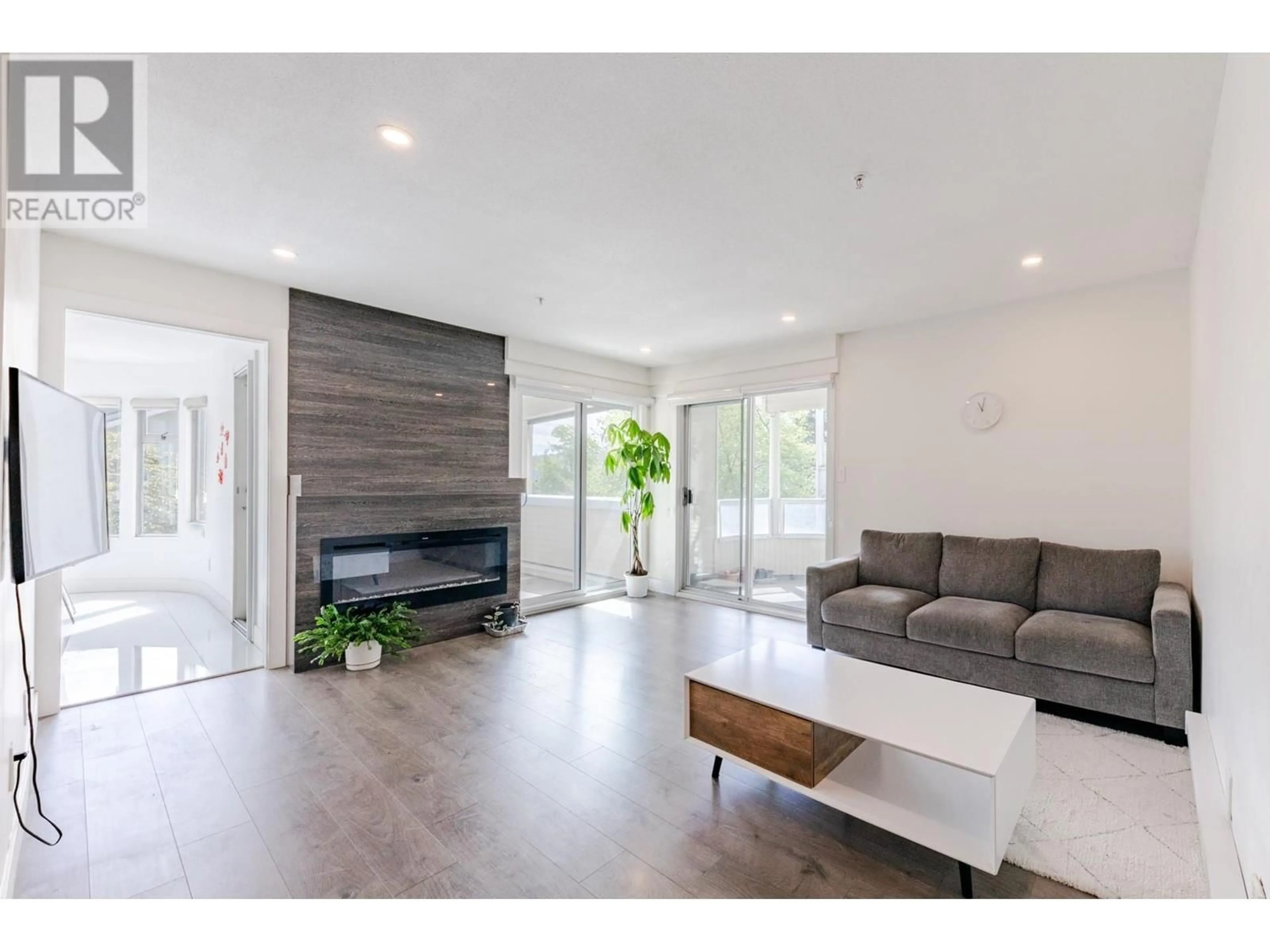 Living room with furniture, wood/laminate floor for 208 - 7620 COLUMBIA STREET, Vancouver British Columbia V5X4S8