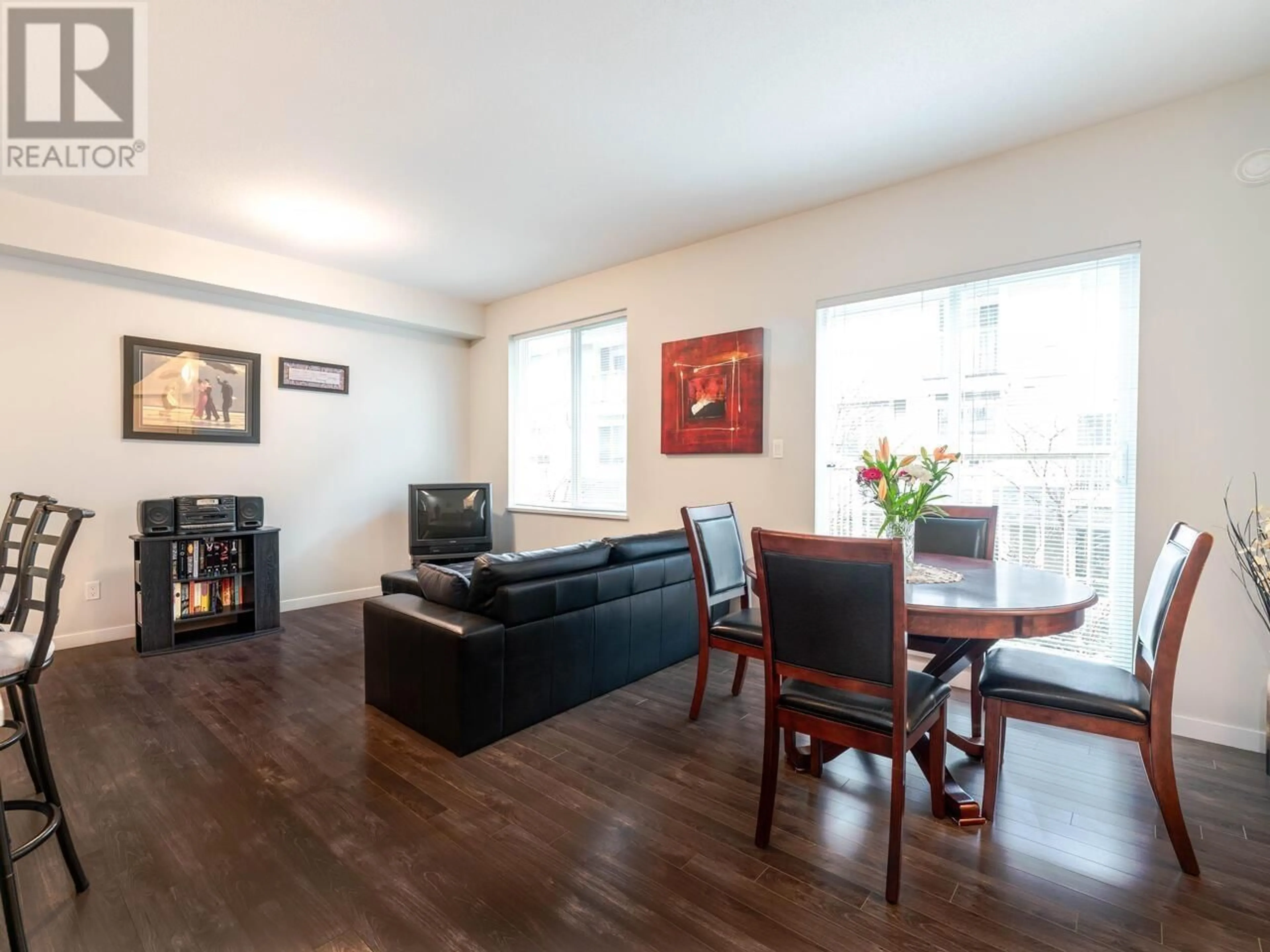 Living room with furniture, wood/laminate floor for 12 - 6965 HASTINGS STREET, Burnaby British Columbia V5B1S9