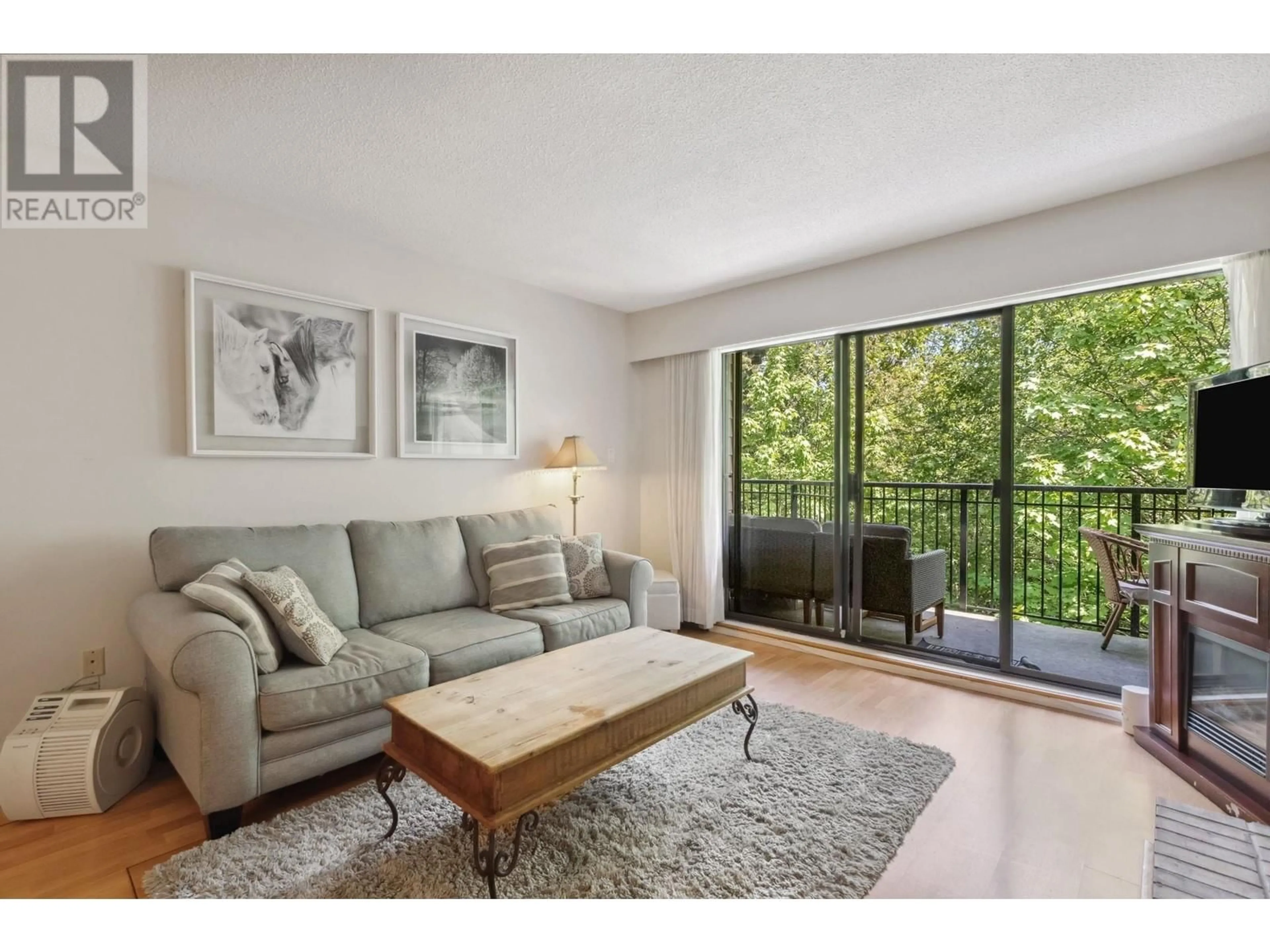 Living room with furniture, wood/laminate floor for 306 - 1385 DRAYCOTT ROAD, North Vancouver British Columbia V7J3K9