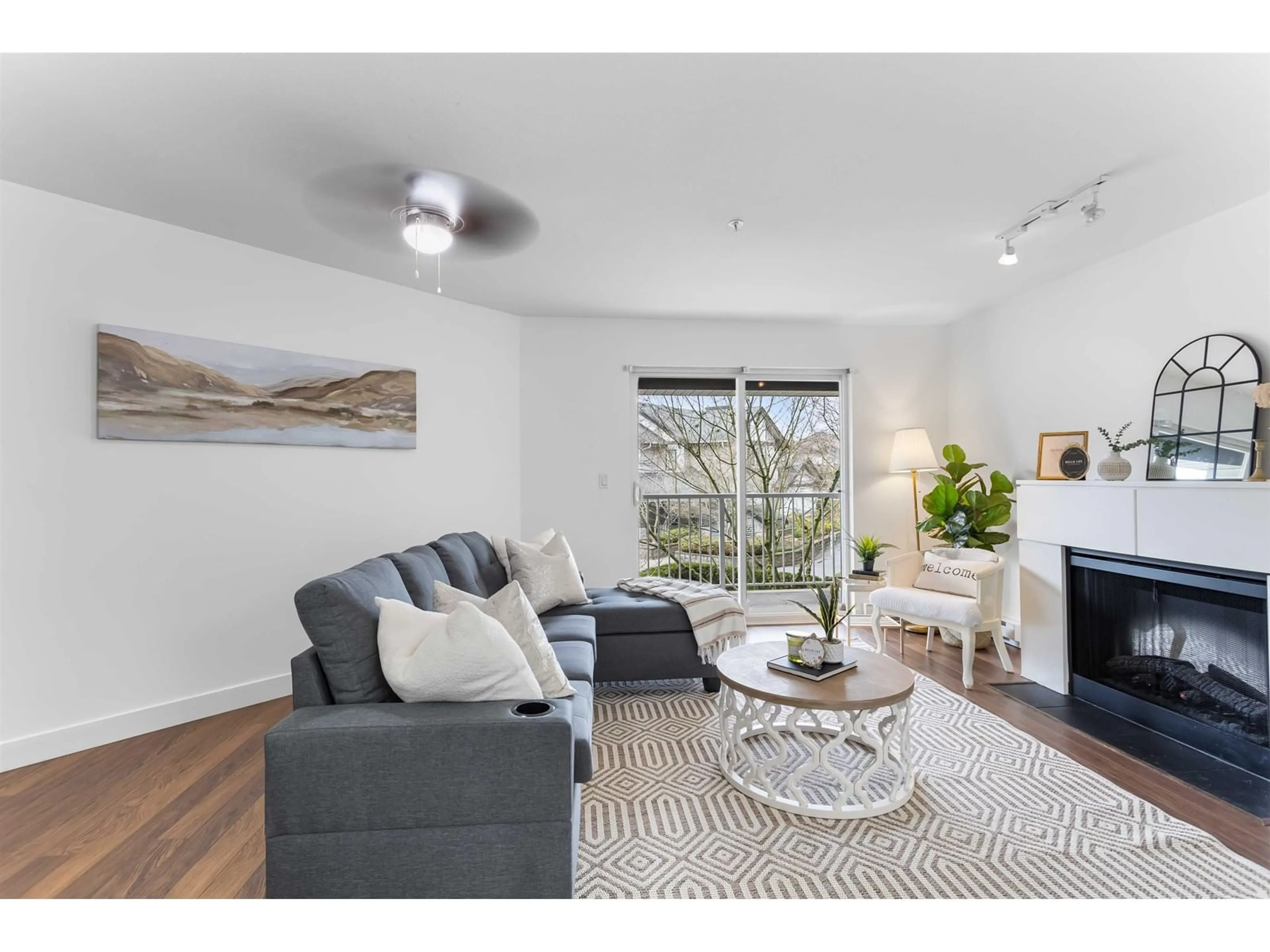 Living room with furniture, wood/laminate floor for 211 - 19340 65, Surrey British Columbia V4N0A3
