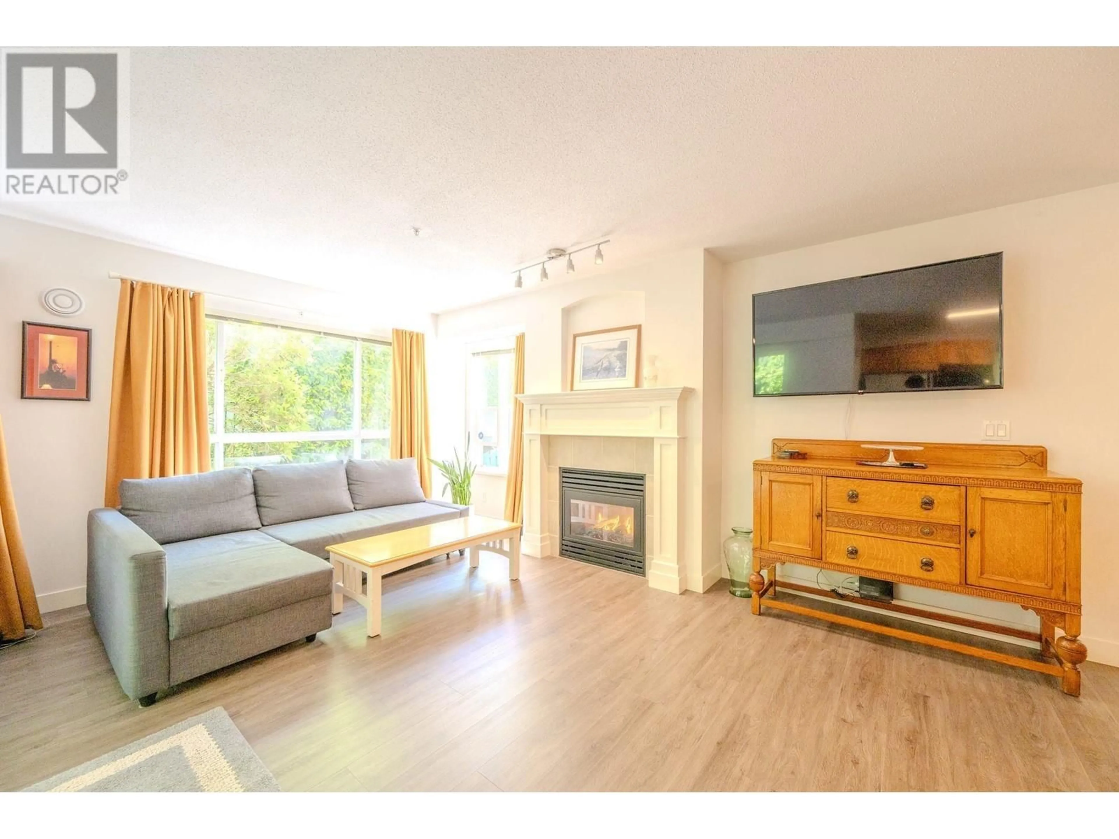 Living room with furniture, wood/laminate floor for 115 - 333 1ST STREET, North Vancouver British Columbia V7L4W9