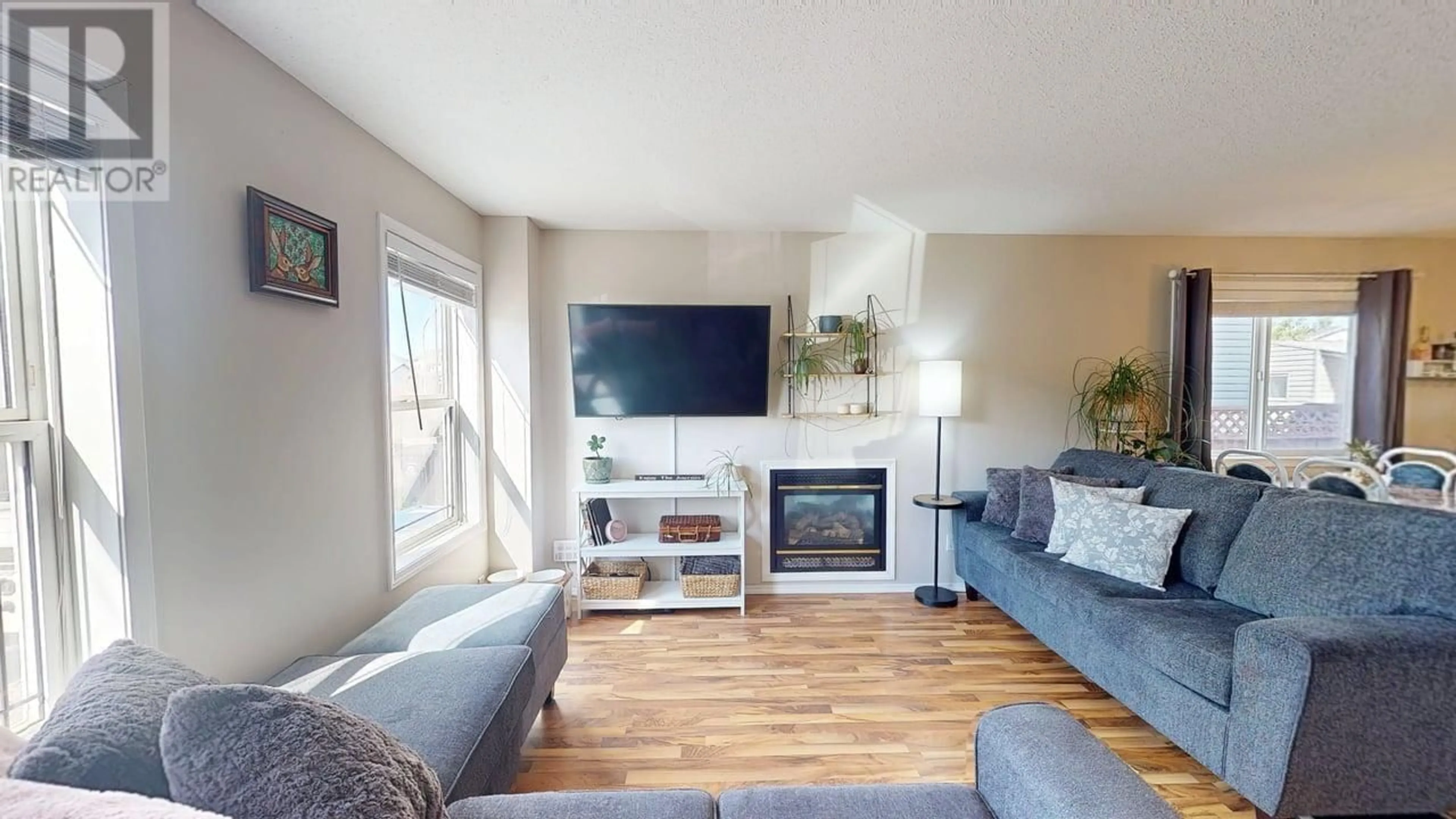 Living room with furniture, wood/laminate floor for 8018 88 AVENUE, Fort St. John British Columbia V1J7G9