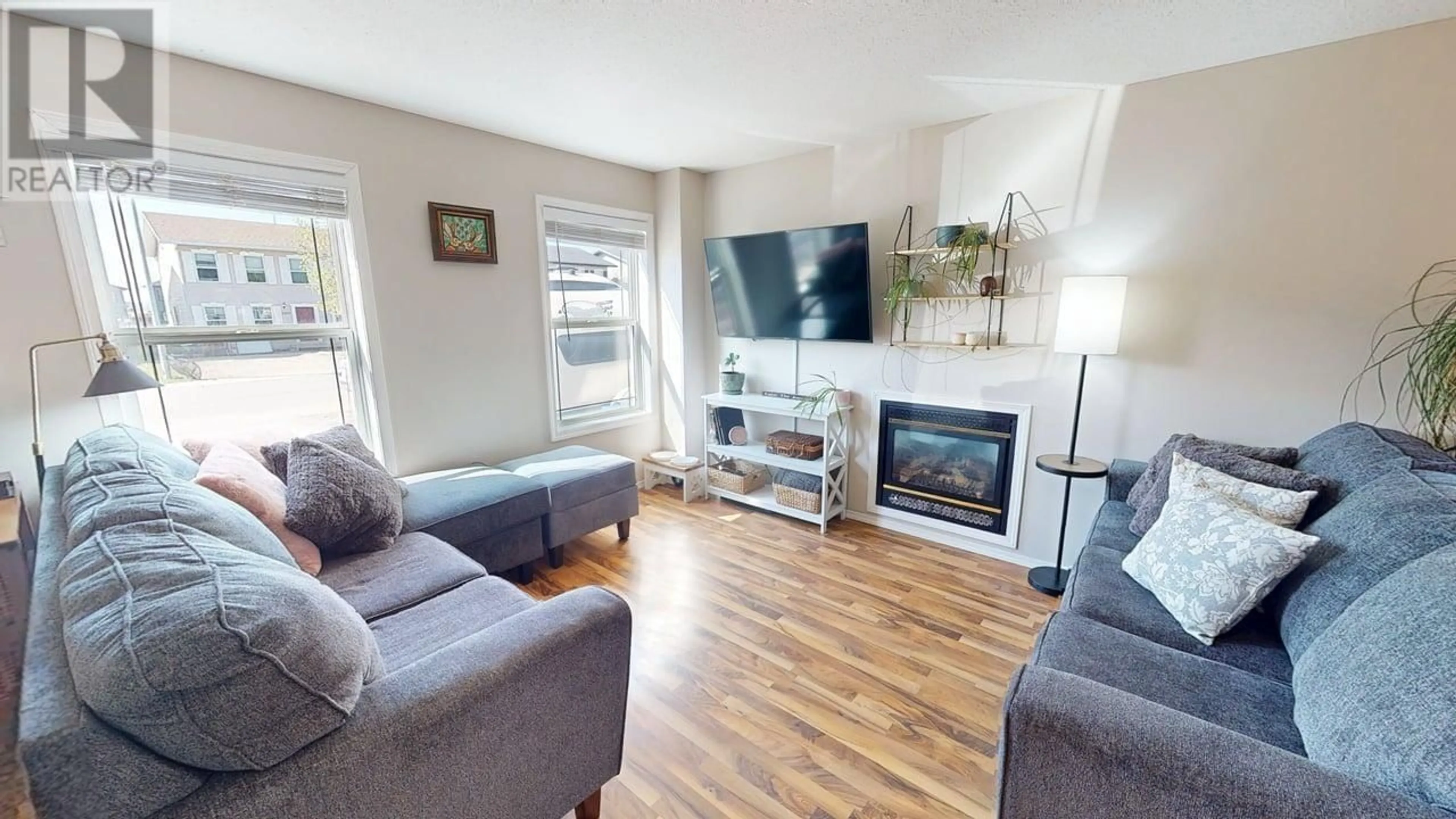 Living room with furniture, wood/laminate floor for 8018 88 AVENUE, Fort St. John British Columbia V1J7G9