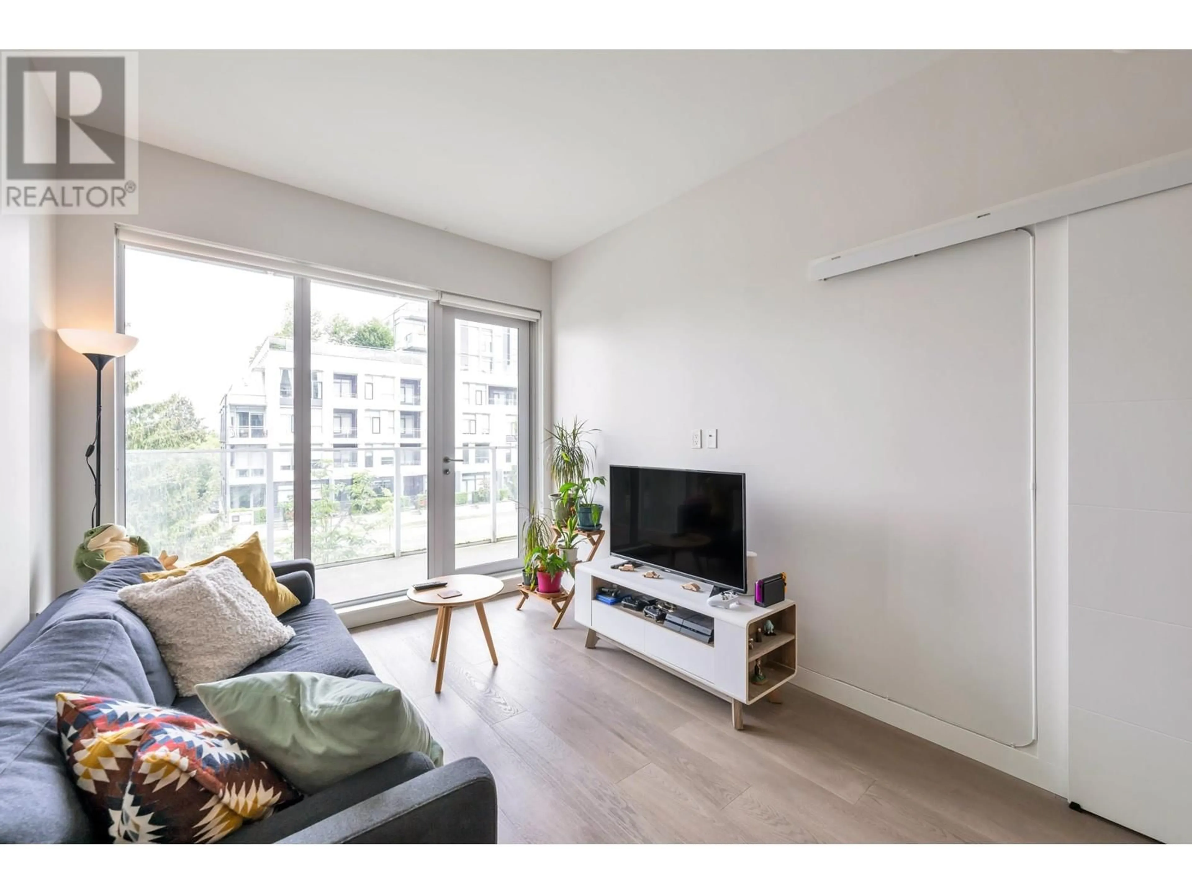 Living room with furniture, wood/laminate floor for 209 - 528 KING EDWARD AVENUE, Vancouver British Columbia V5Z2C3