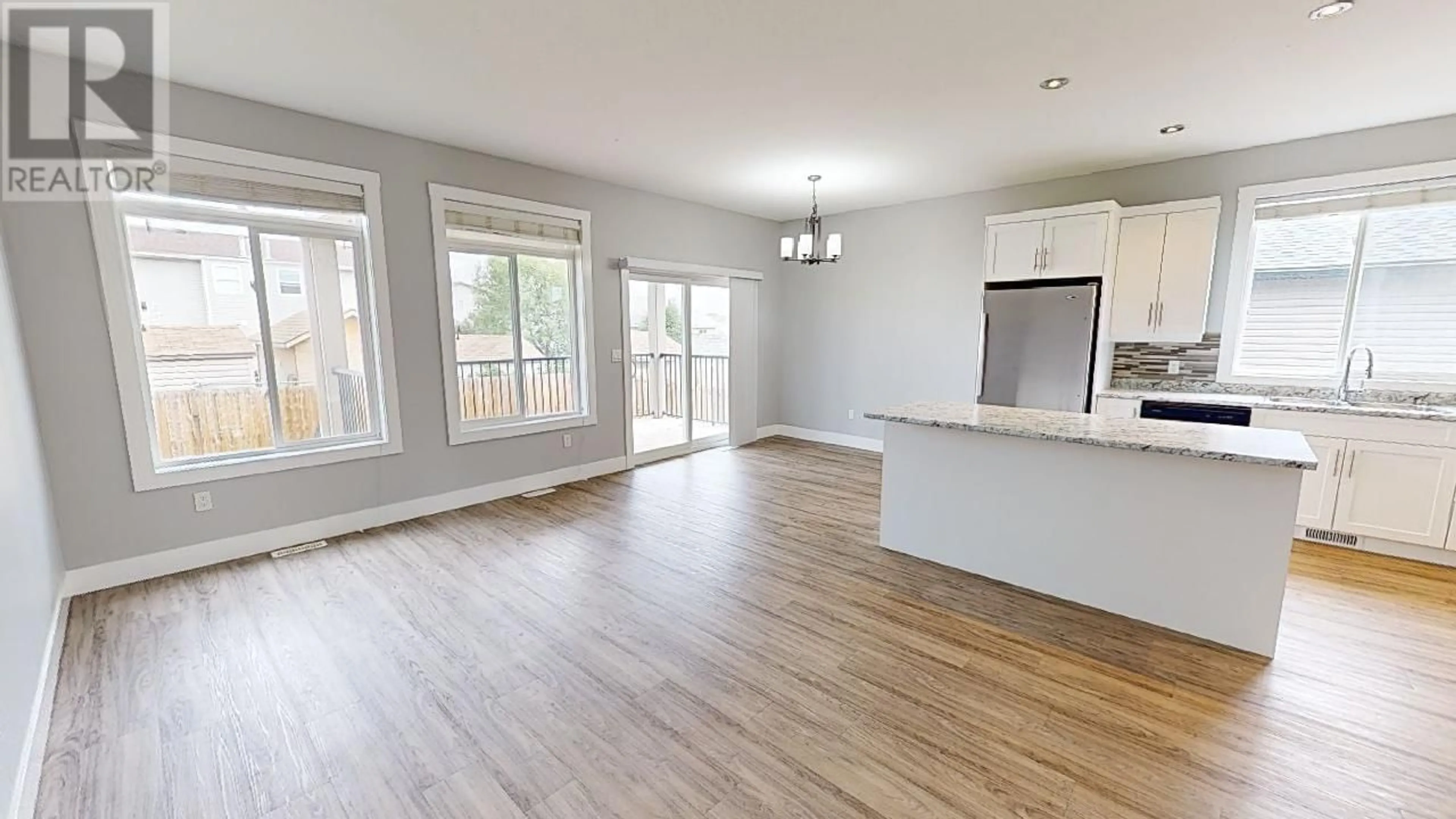 Open concept kitchen, wood/laminate floor for 8332 88 AVENUE, Fort St. John British Columbia V1J0S2
