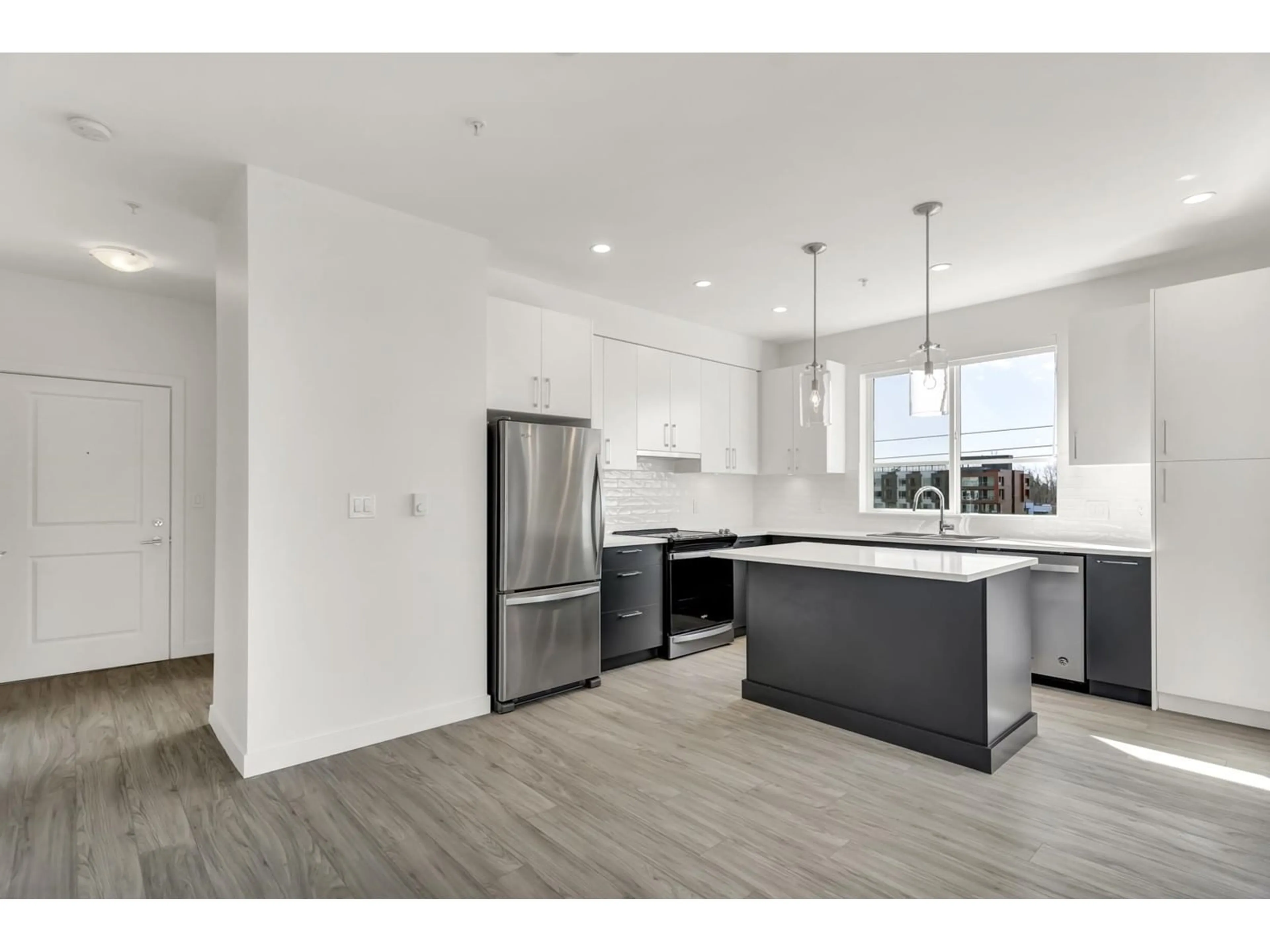 Open concept kitchen, wood/laminate floor for A409 - 20834 80, Langley British Columbia V2Y2C8
