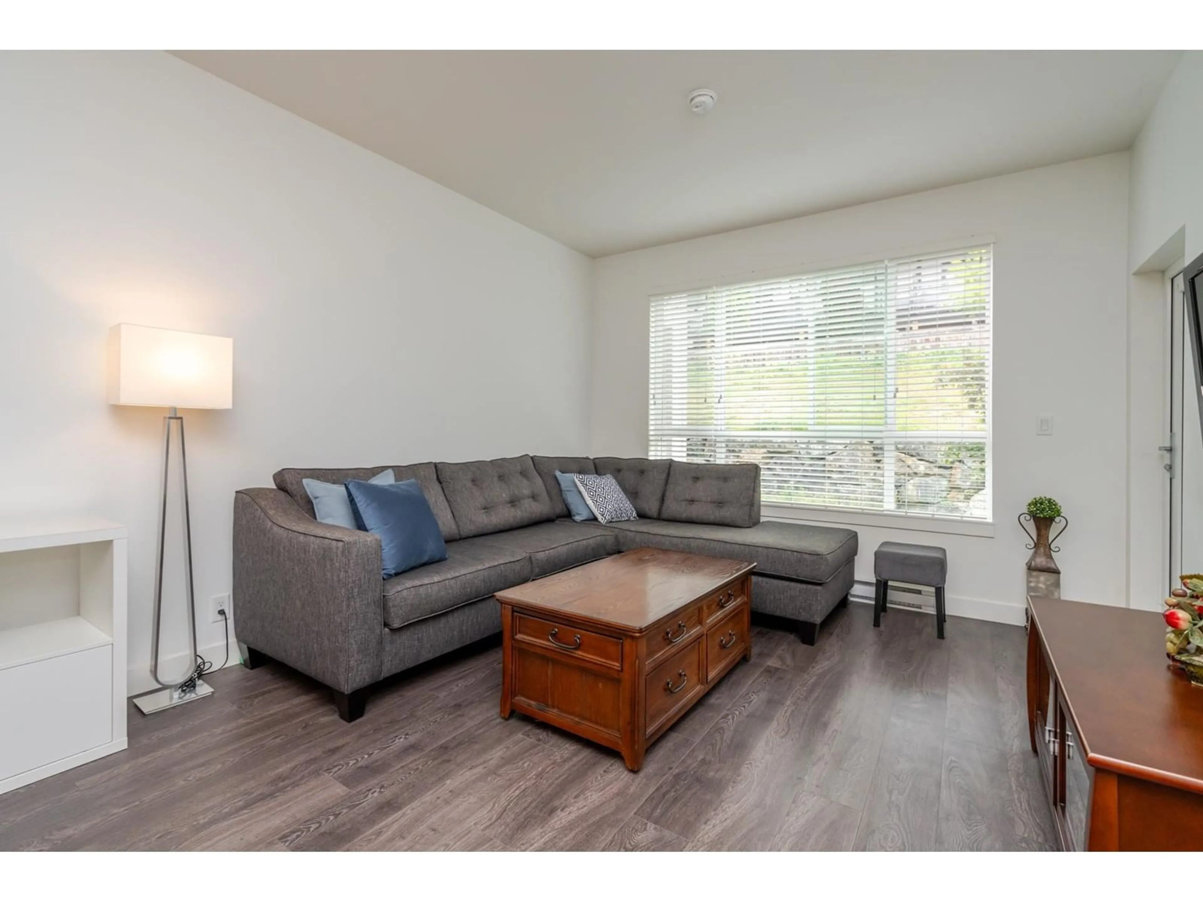 Living room with furniture, wood/laminate floor for 209 - 16396 64, Surrey British Columbia V3S6X6