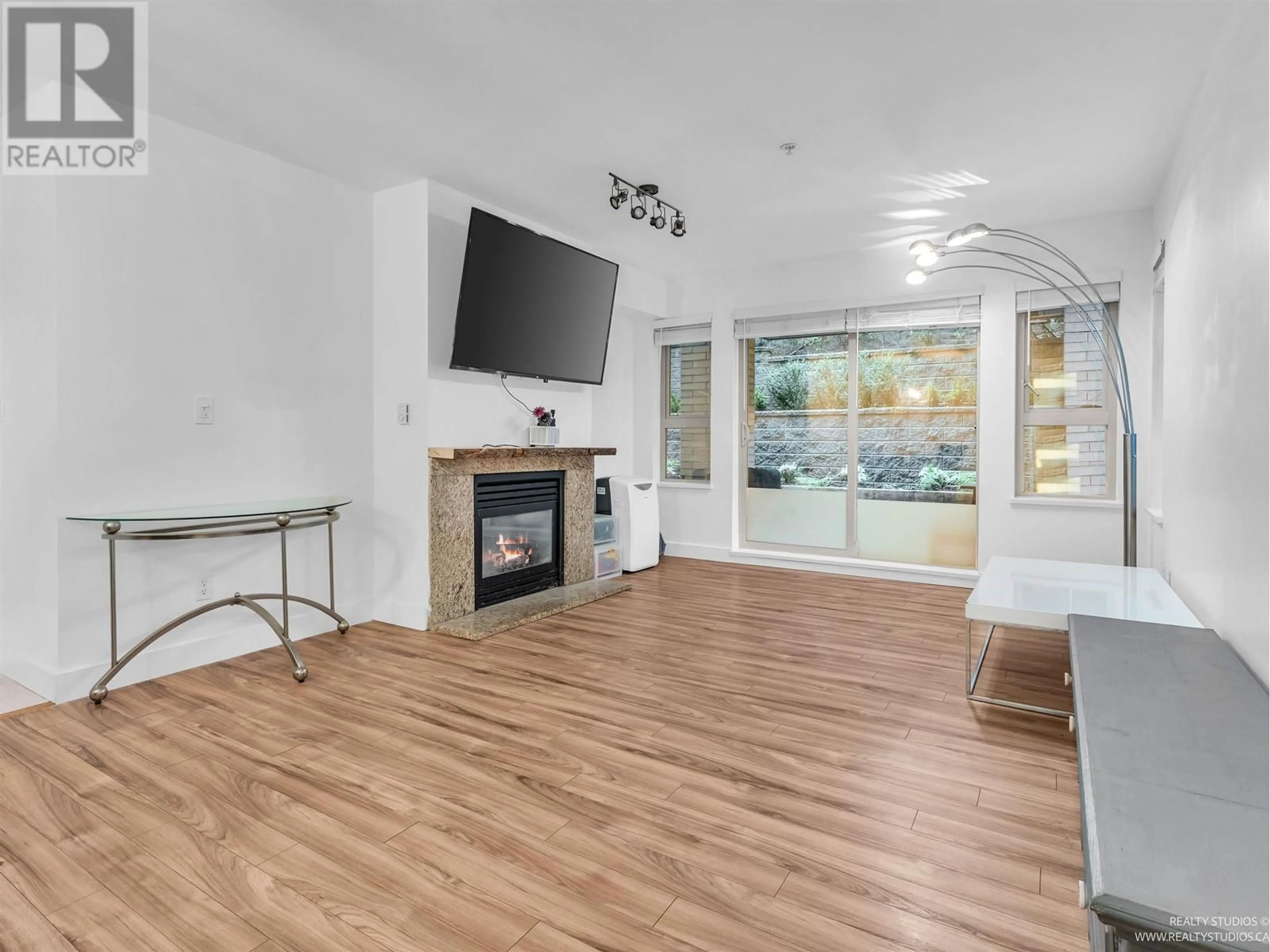 Living room with furniture, wood/laminate floor for 104 - 9329 UNIVERSITY CRESCENT, Burnaby British Columbia V5A4Y4