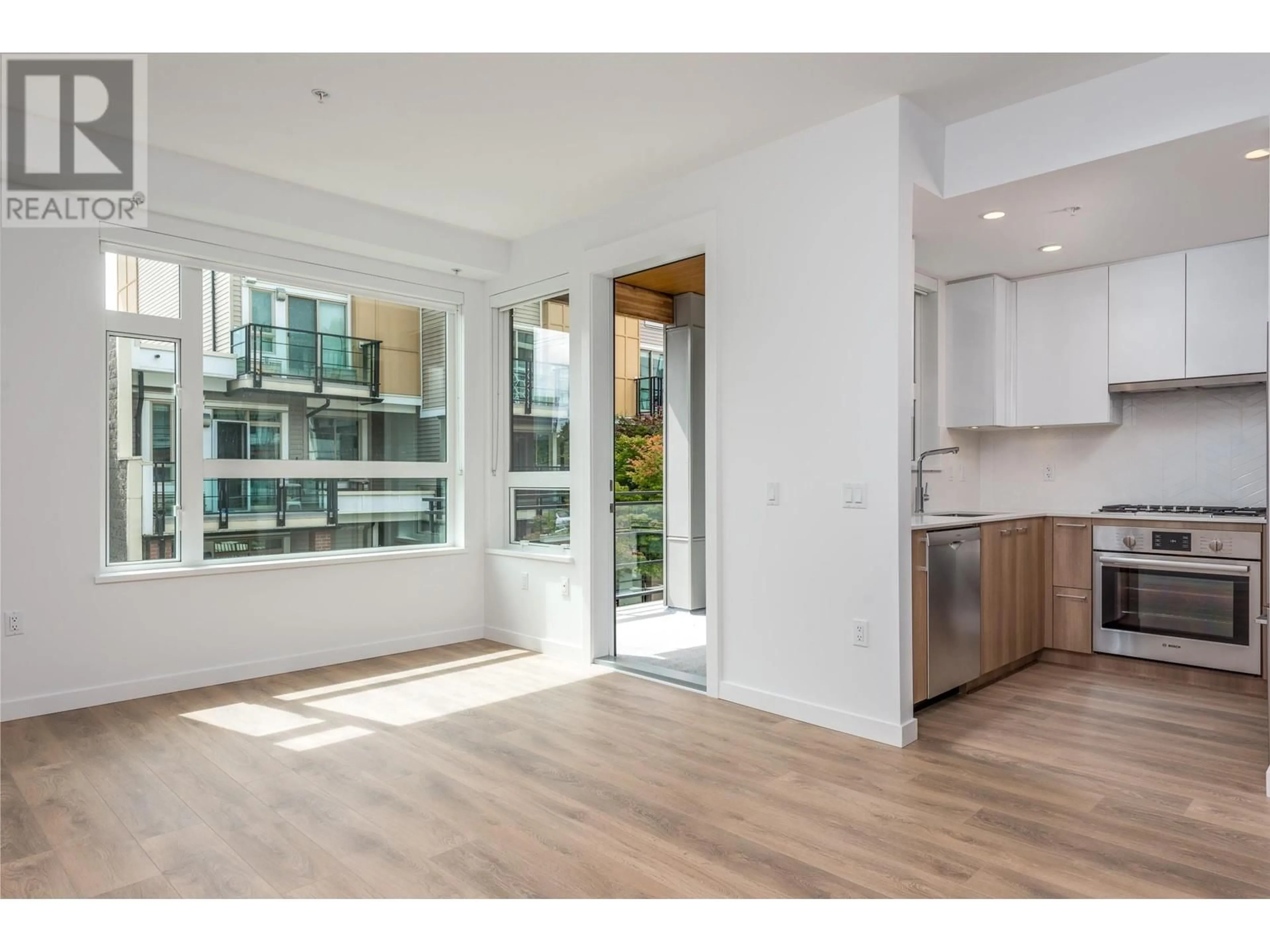 Open concept kitchen, wood/laminate floor for 111 - 715 15TH STREET, North Vancouver British Columbia V7M1T2
