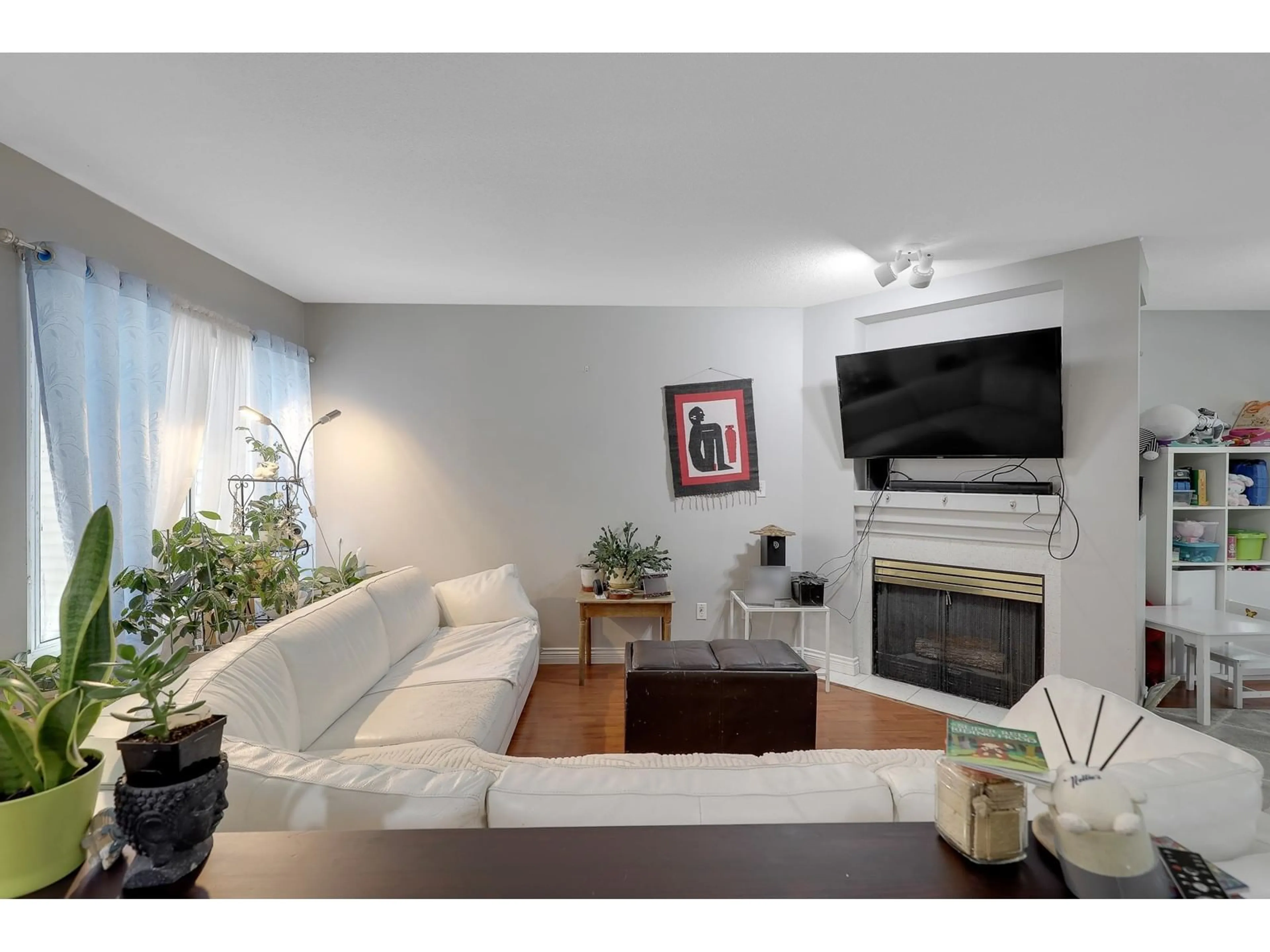 Living room with furniture, wood/laminate floor for 411 - 13900 HYLAND, Surrey British Columbia V3W2C3