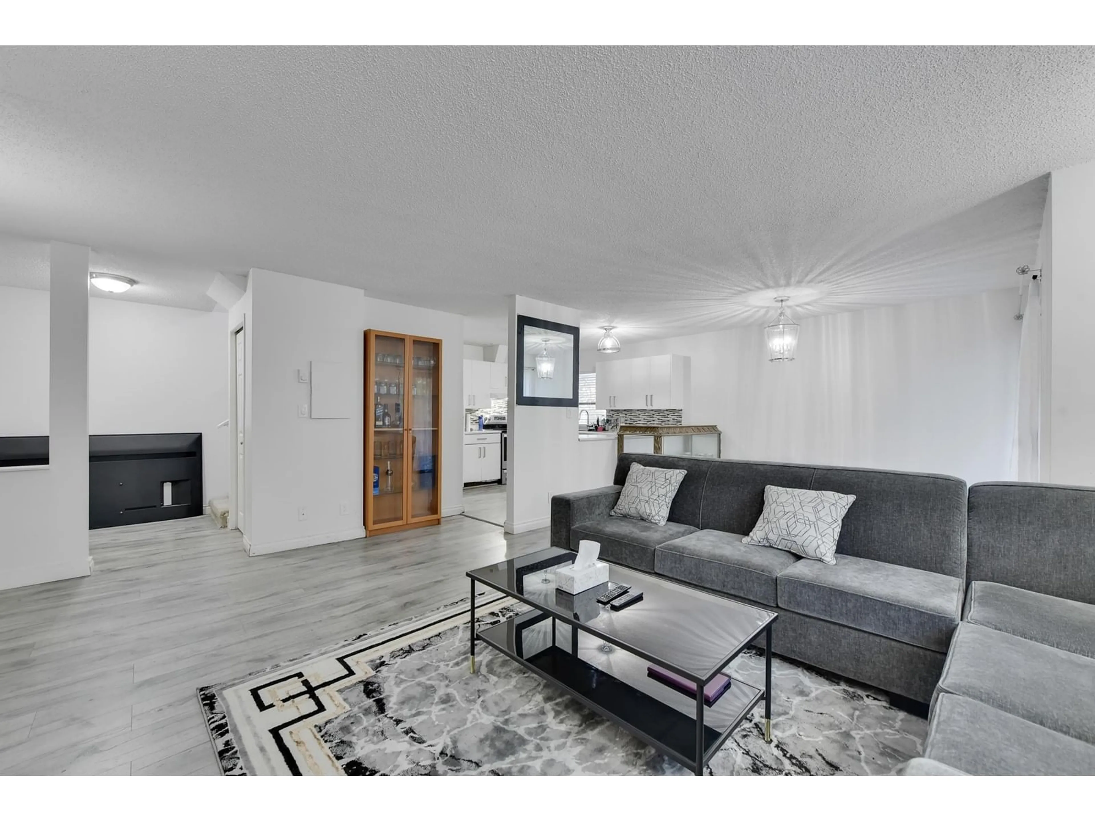 Living room with furniture, wood/laminate floor for 203 - 7064 133B, Surrey British Columbia V3W8A4