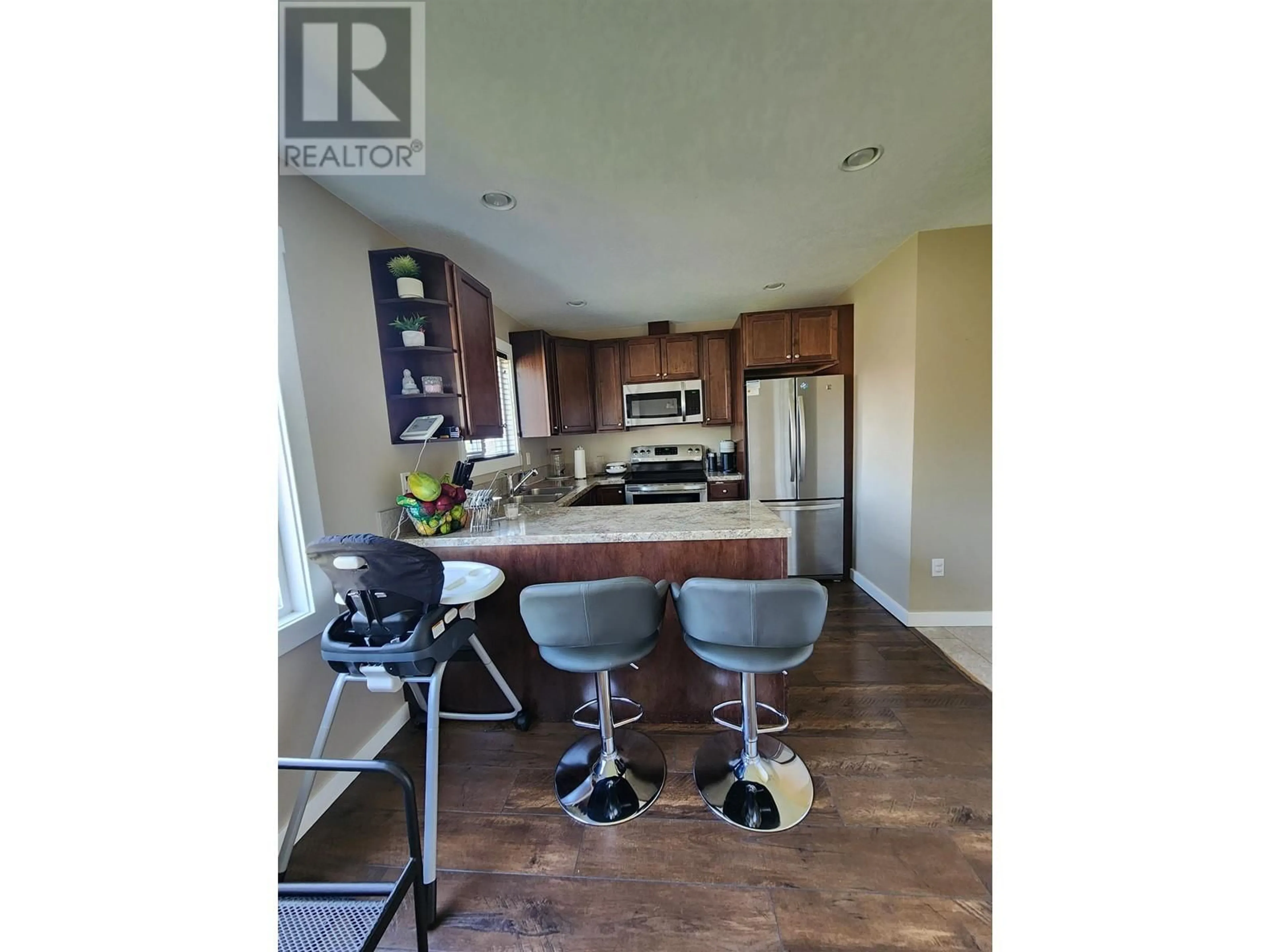 Open concept kitchen, wood/laminate floor for 7926 87 AVENUE, Fort St. John British Columbia V1J0M4
