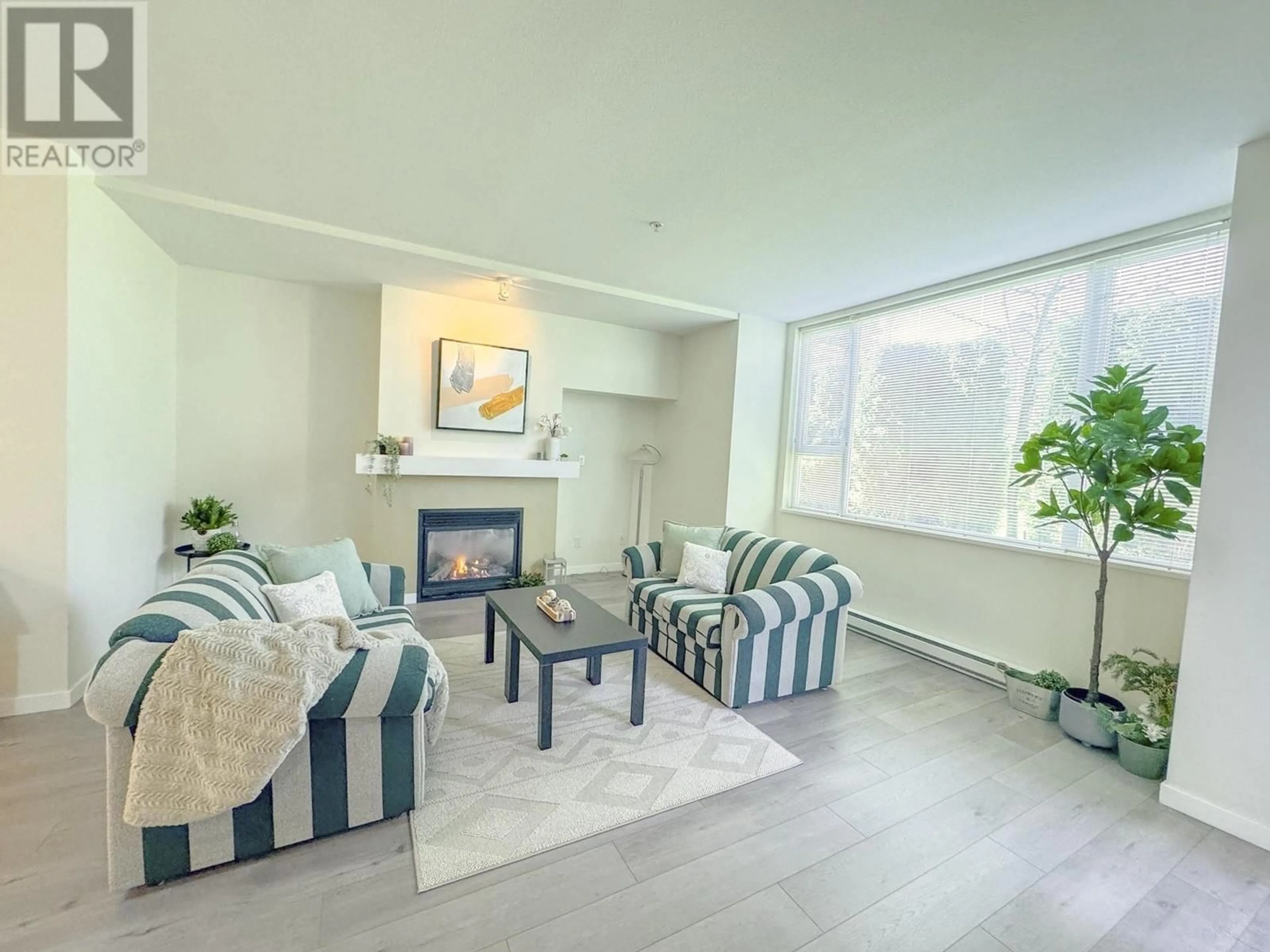 Living room with furniture, wood/laminate floor for 104 - 7089 MONT ROYAL SQUARE, Vancouver British Columbia V5S4W6
