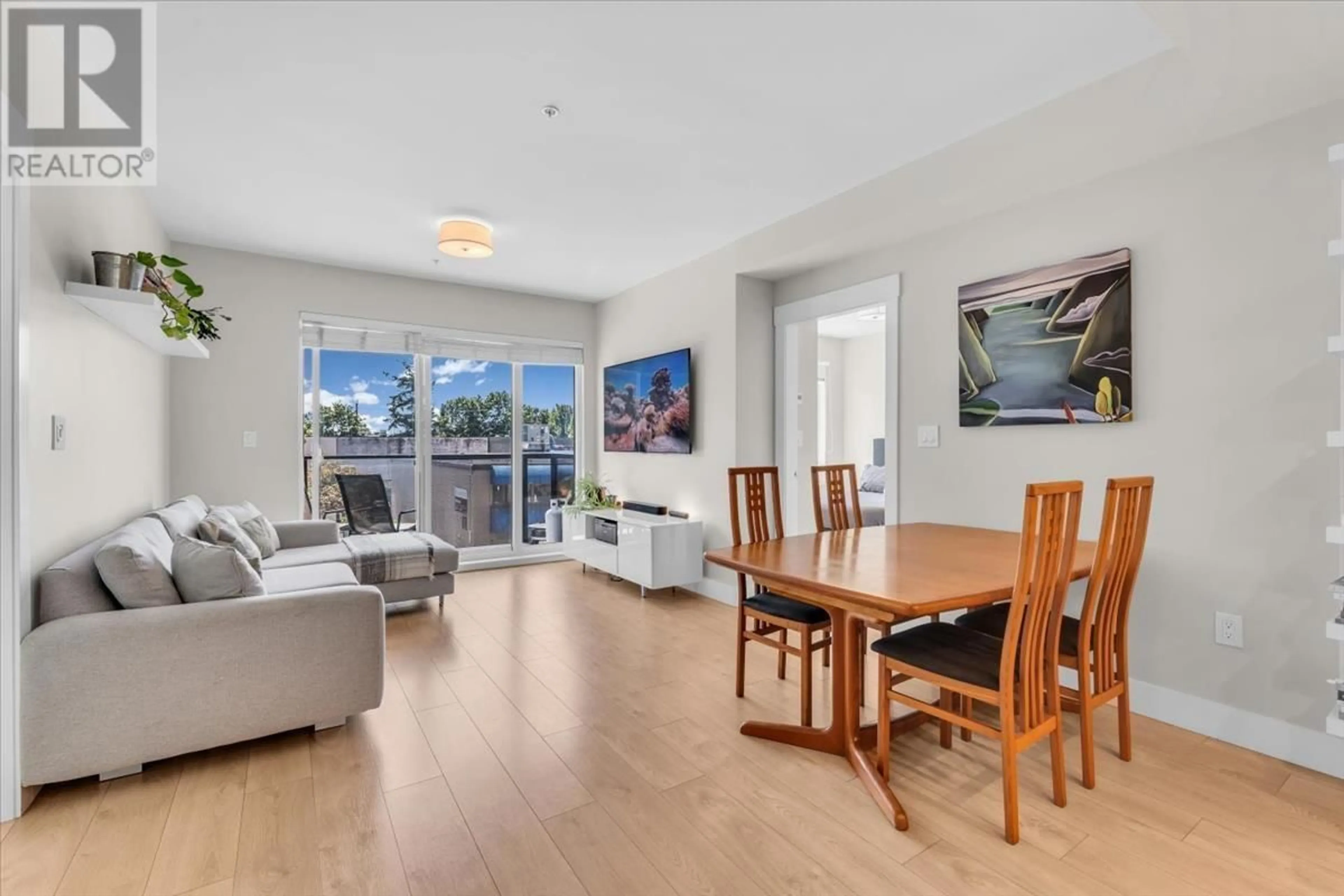 Living room with furniture, wood/laminate floor for 211 - 1496 CHARLOTTE ROAD, North Vancouver British Columbia V7J0C9