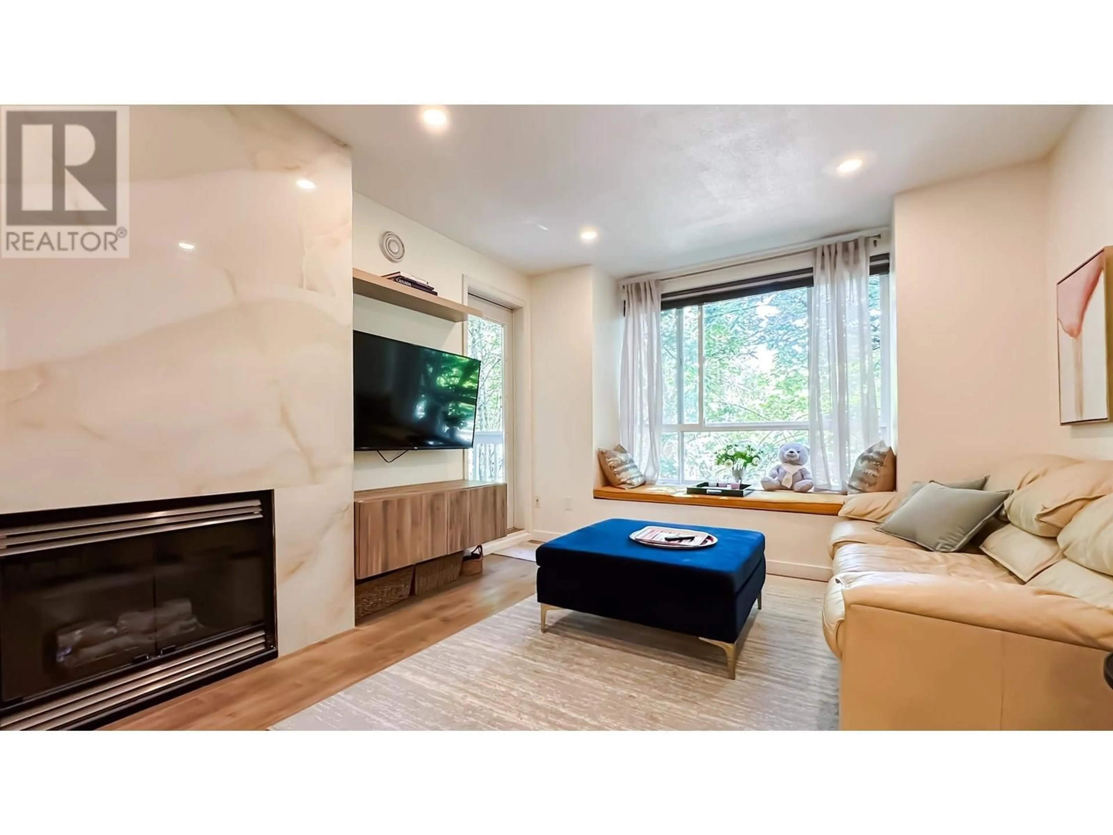 Living room with furniture, wood/laminate floor for 317 - 6833 VILLAGE, Burnaby British Columbia V5E4M1