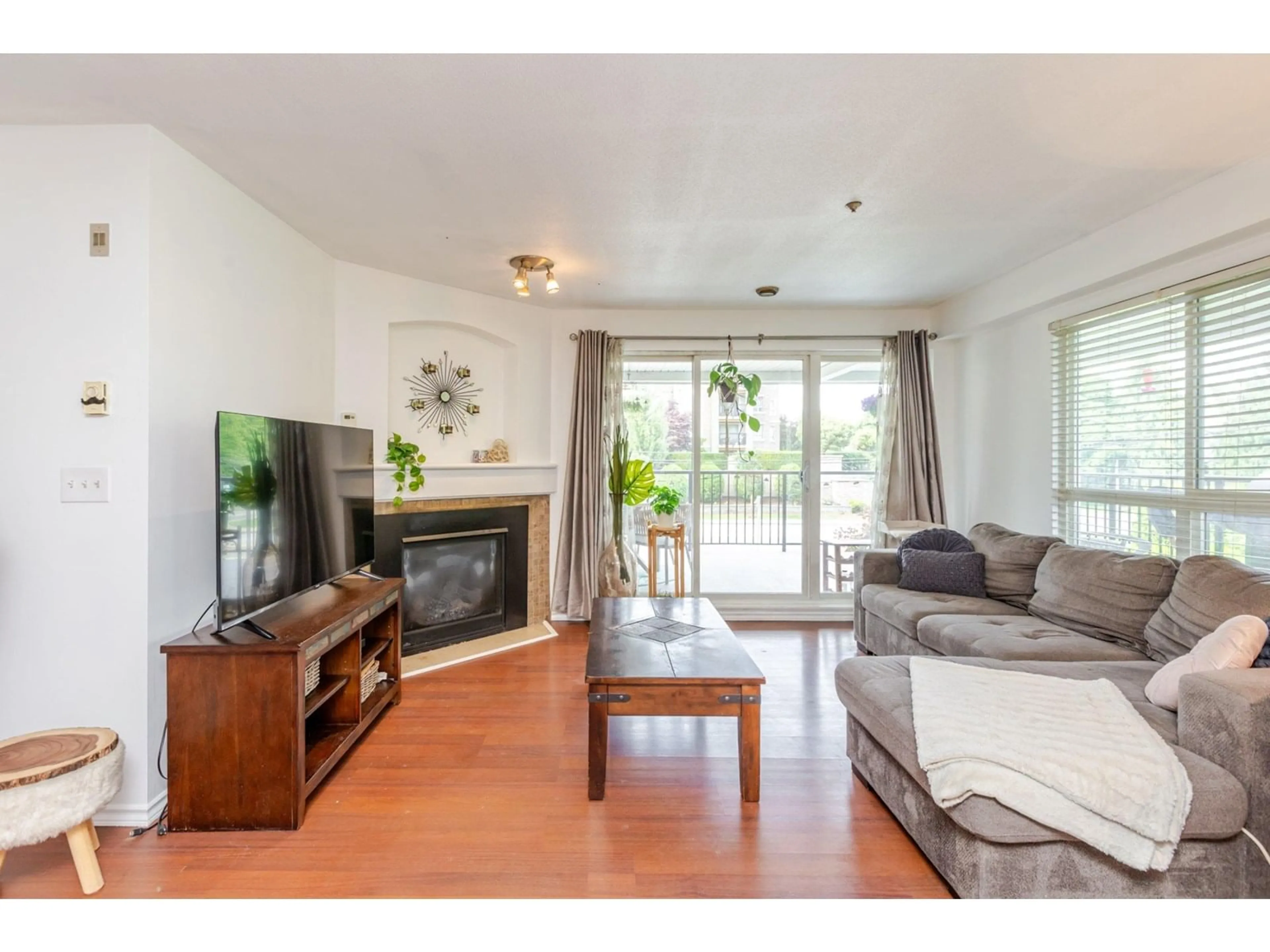 Living room with furniture, wood/laminate floor for 103 - 20976 56, Langley British Columbia V3A7Z2