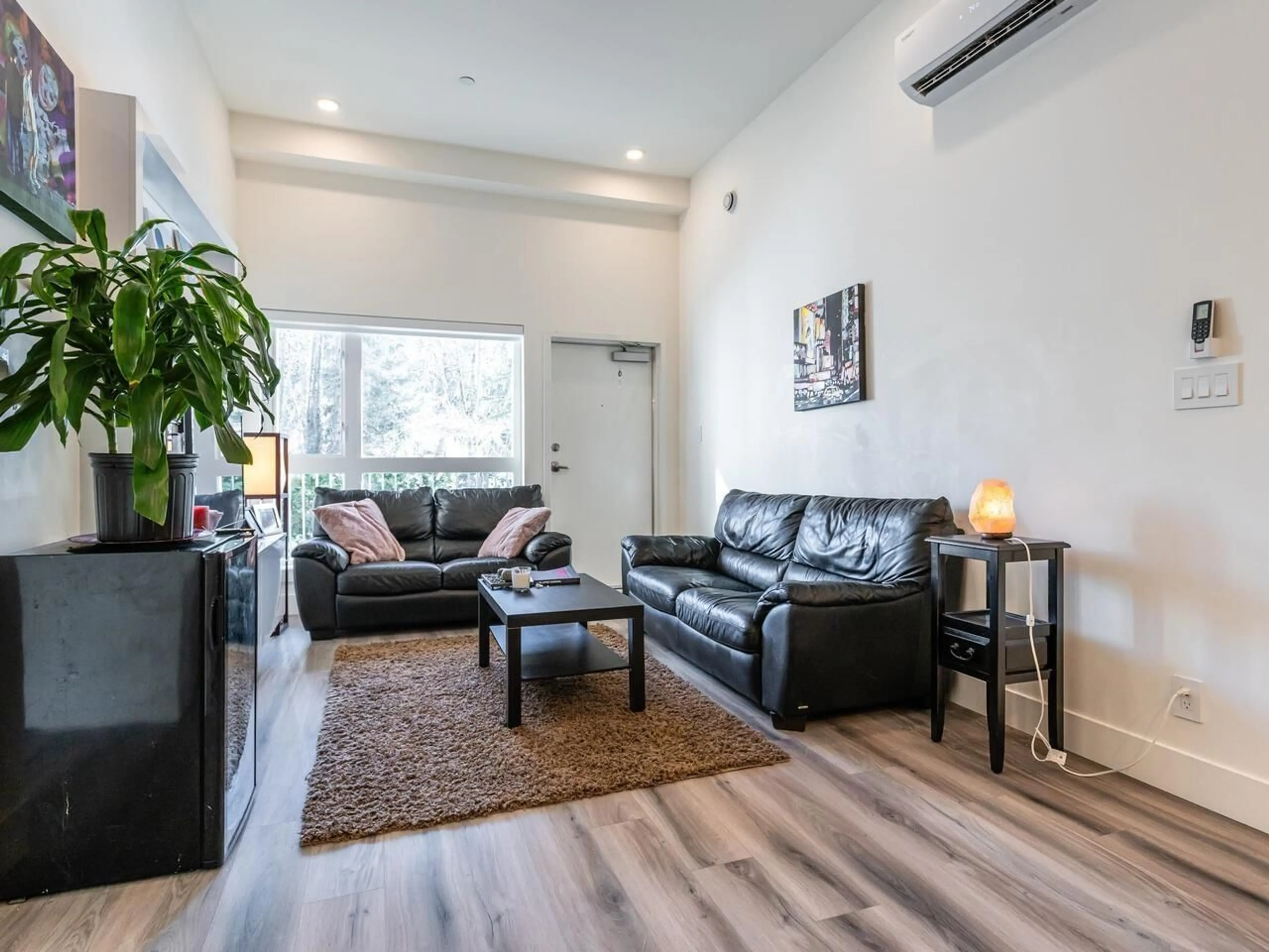 Living room with furniture, wood/laminate floor for A102 - 8447 202, Langley British Columbia V2Y2B7