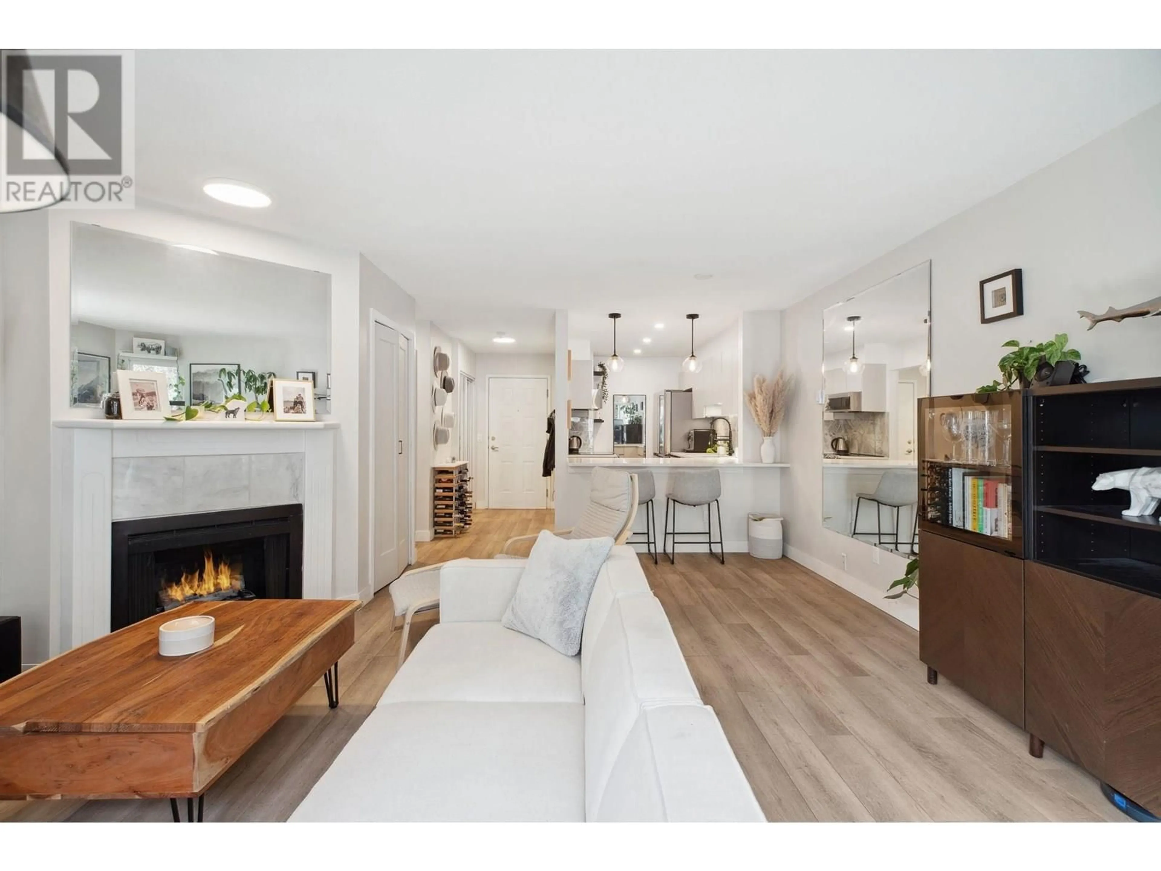 Living room with furniture, wood/laminate floor for 102 - 1535 CHESTERFIELD AVENUE, North Vancouver British Columbia V7M2N5