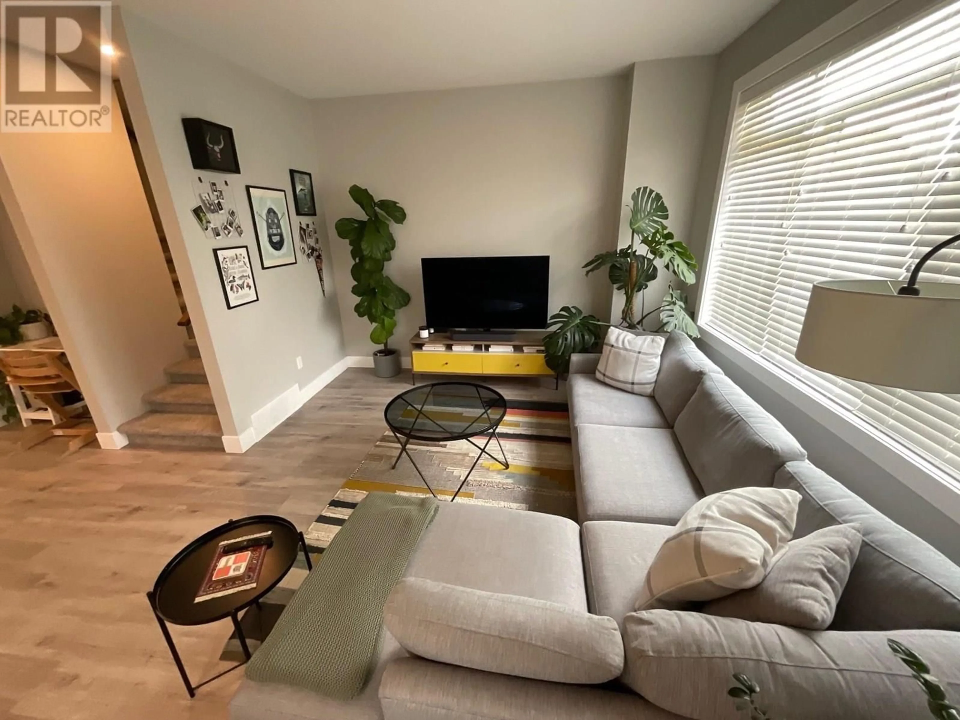 Living room with furniture, wood/laminate floor for 8404 88 AVENUE, Fort St. John British Columbia V1J0S2