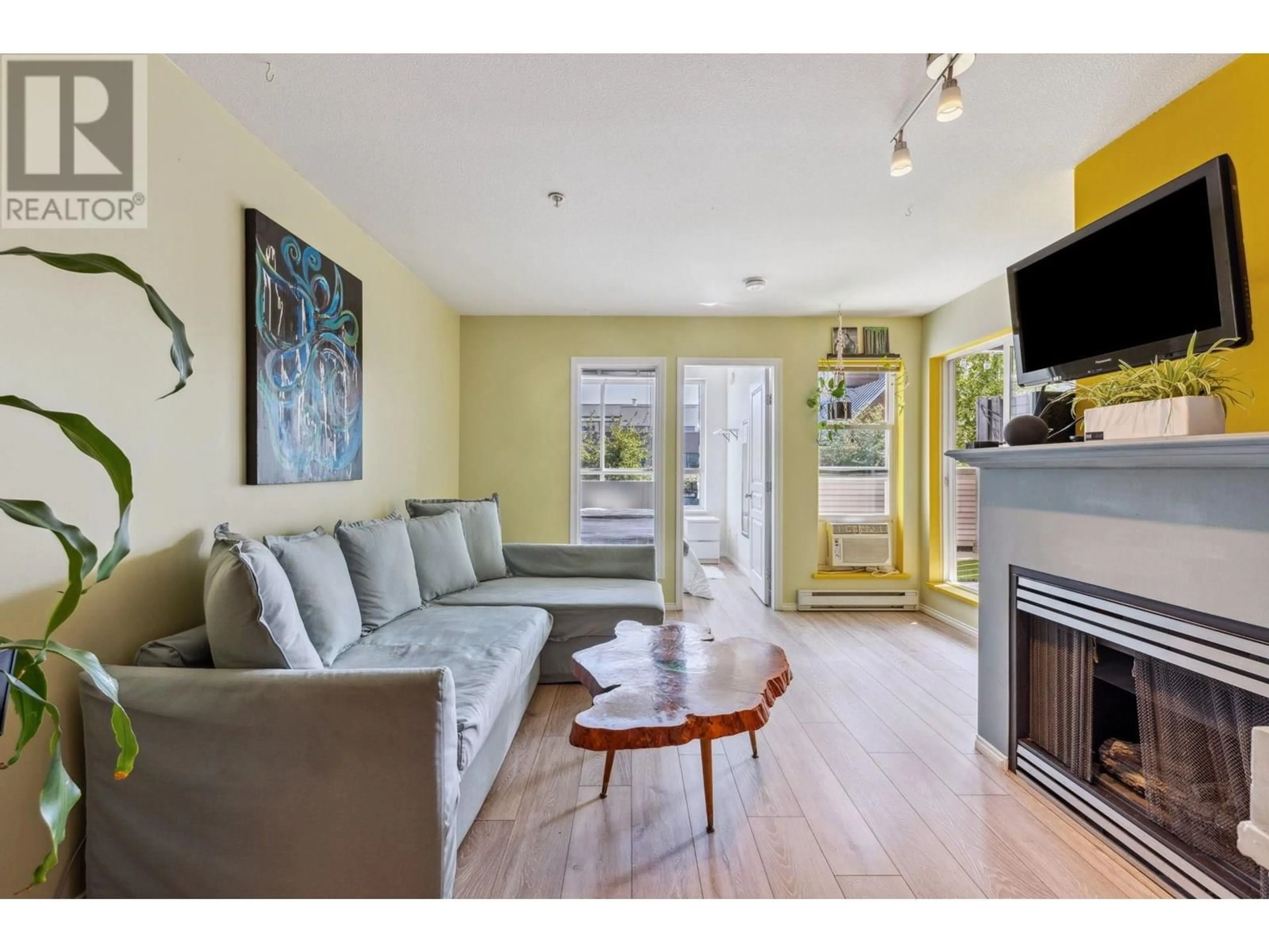 Living room with furniture, wood/laminate floor for 202 - 3939 HASTINGS STREET, Burnaby British Columbia V5C2H8