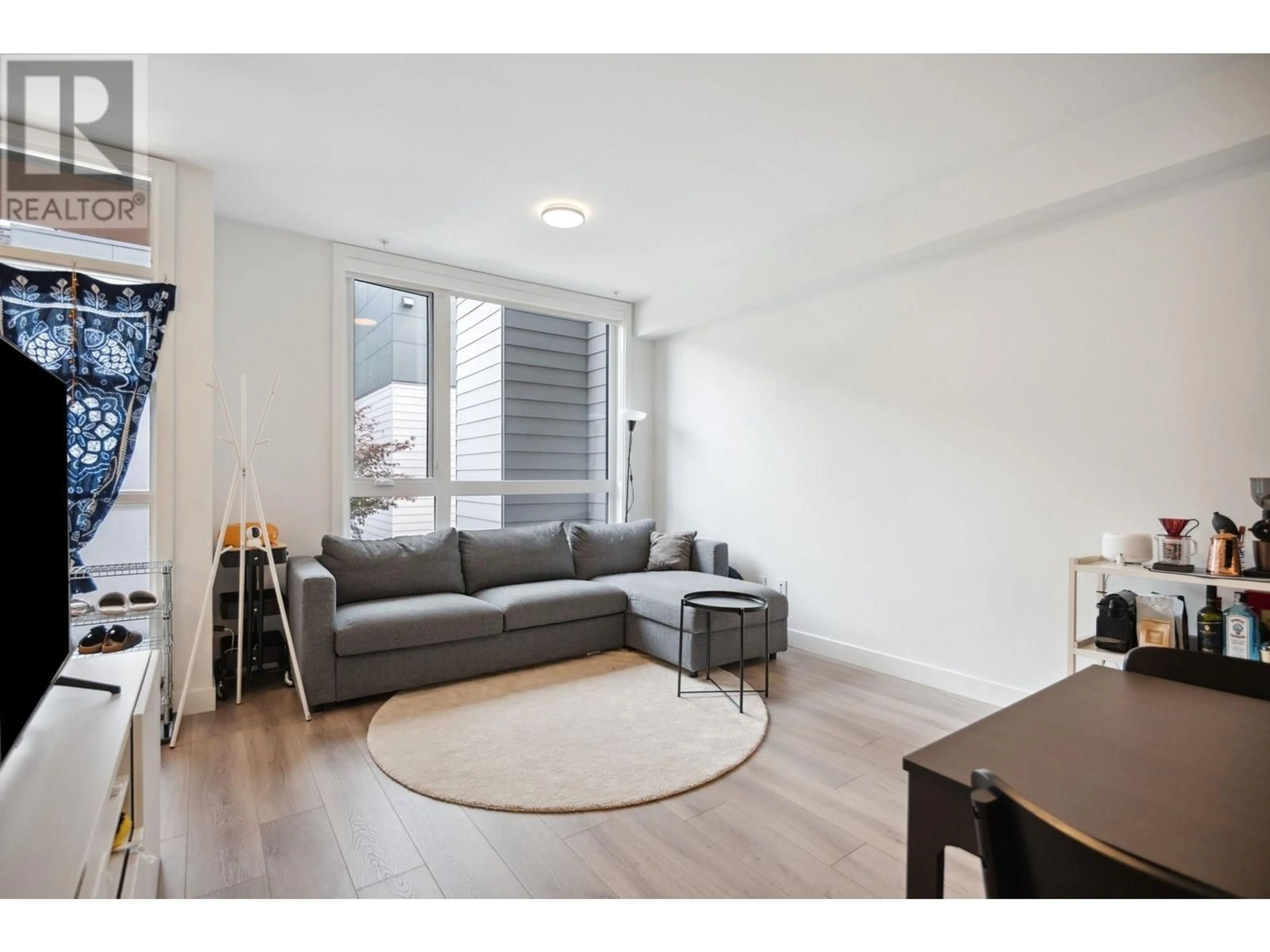 Living room with furniture, wood/laminate floor for 206 - 6085 IRMIN STREET, Burnaby British Columbia V5J5C5