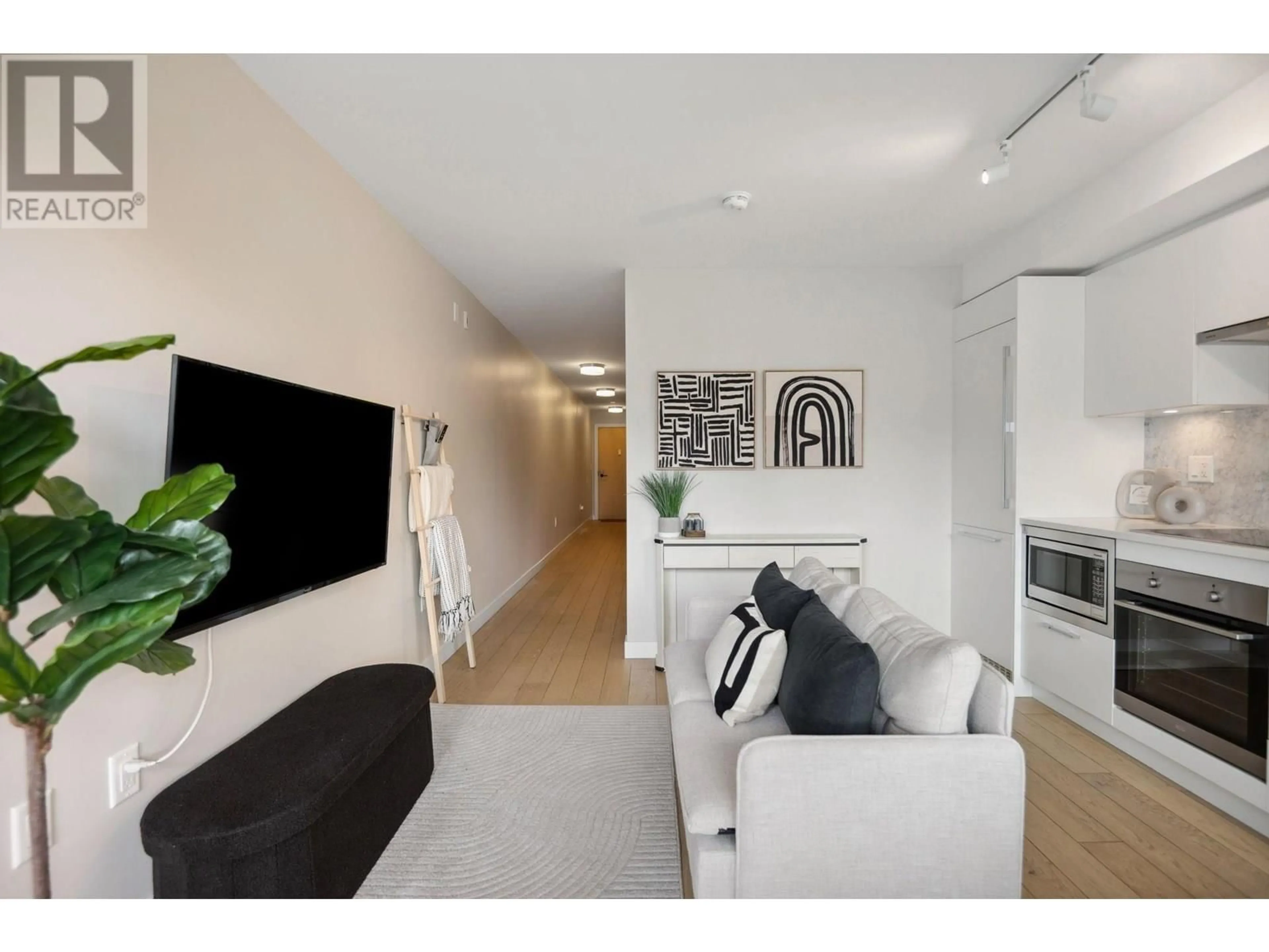 Living room with furniture, wood/laminate floor for 208 - 2508 FRASER STREET, Vancouver British Columbia V5T3V4