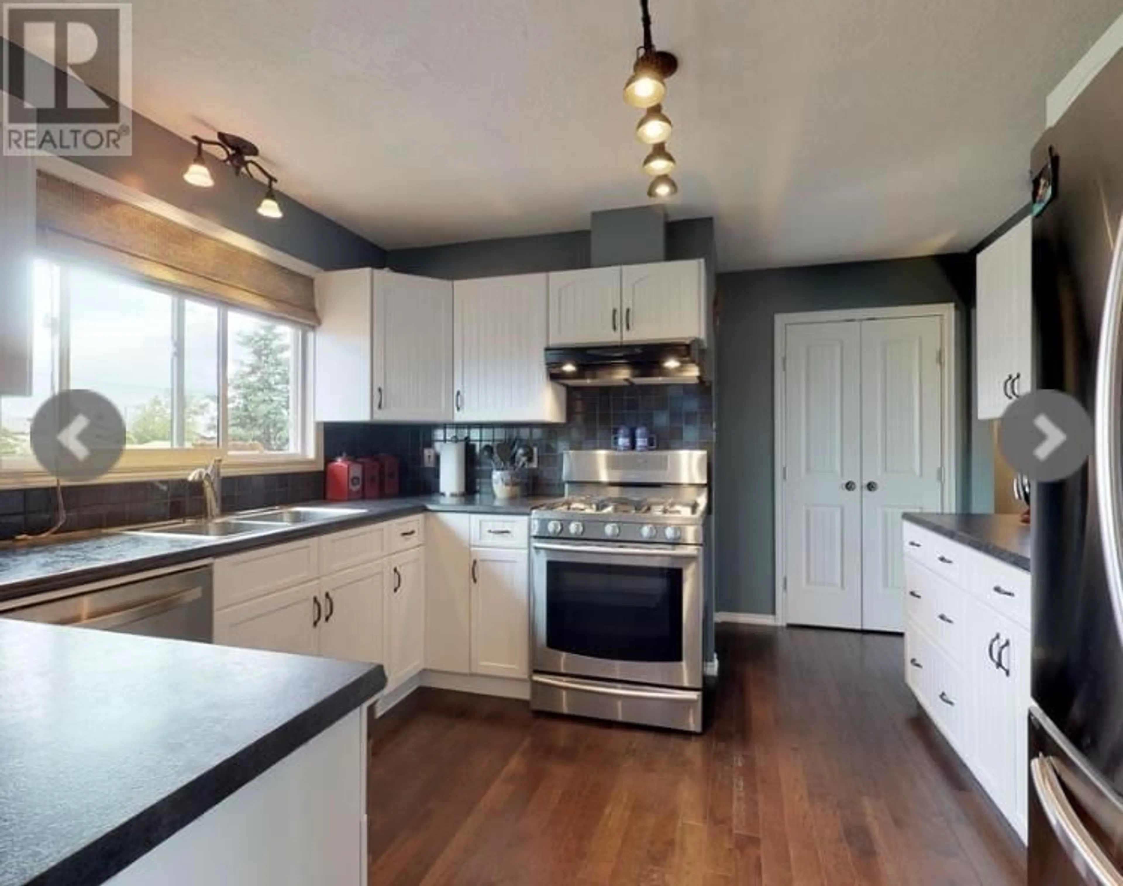 Open concept kitchen, wood/laminate floor for 9007 103A AVENUE, Fort St. John British Columbia V1J2J4