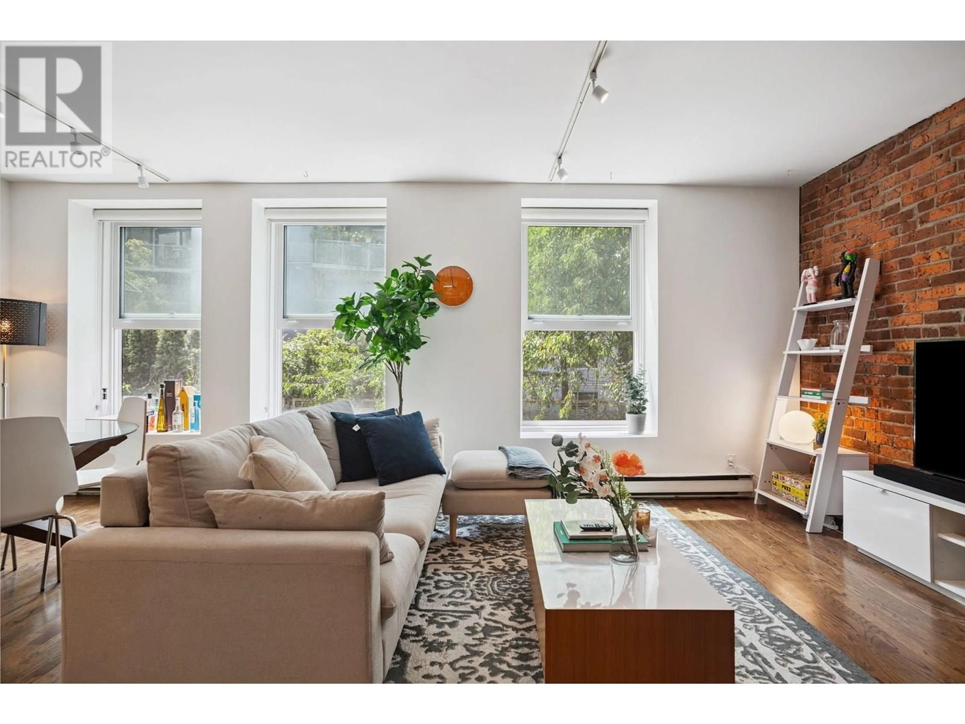 Living room with furniture, wood/laminate floor for 203 - 150 ALEXANDER STREET, Vancouver British Columbia V6A1B5