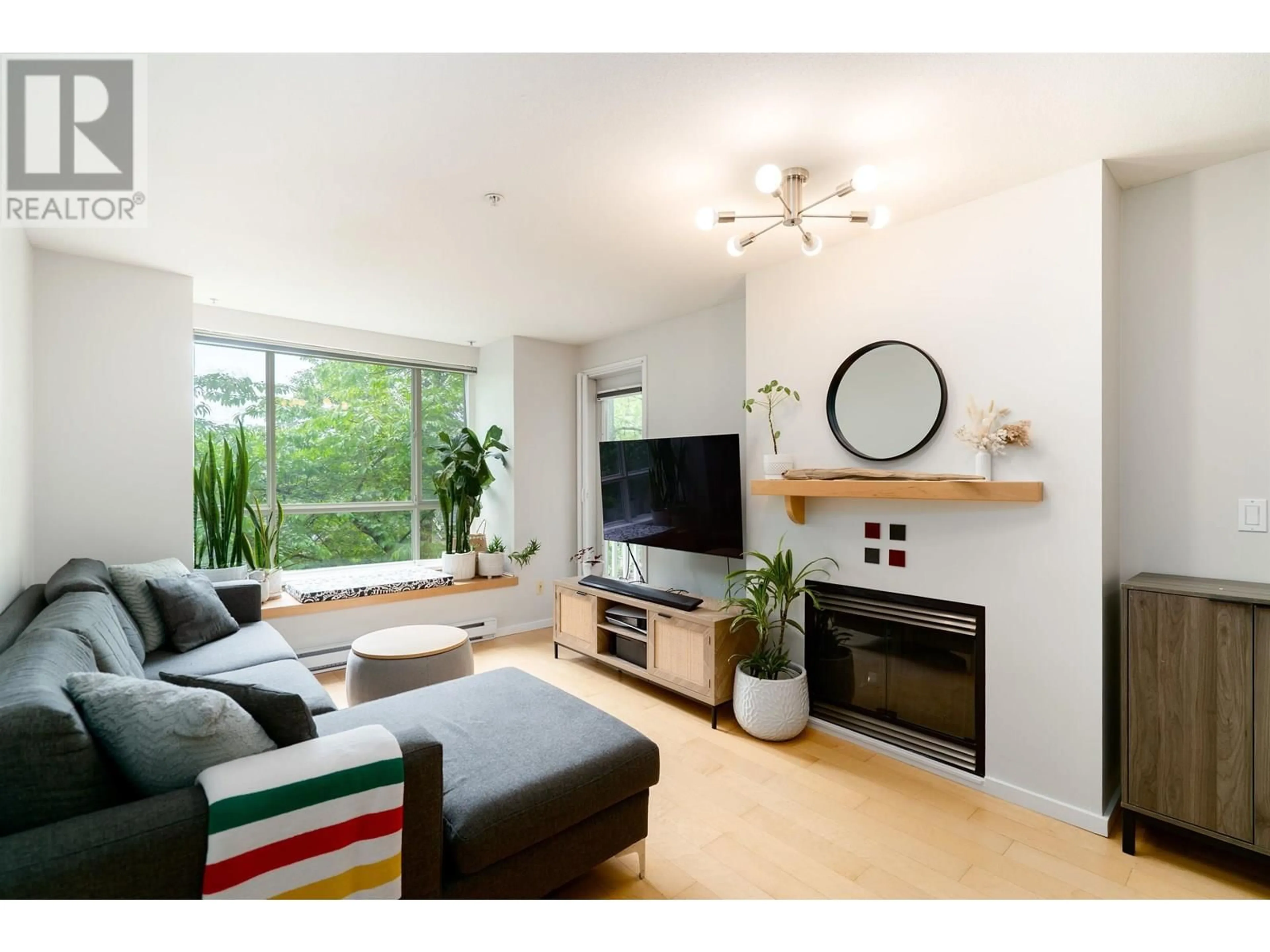 Living room with furniture, wood/laminate floor for 202 - 6833 VILLAGE, Burnaby British Columbia V5E4M1