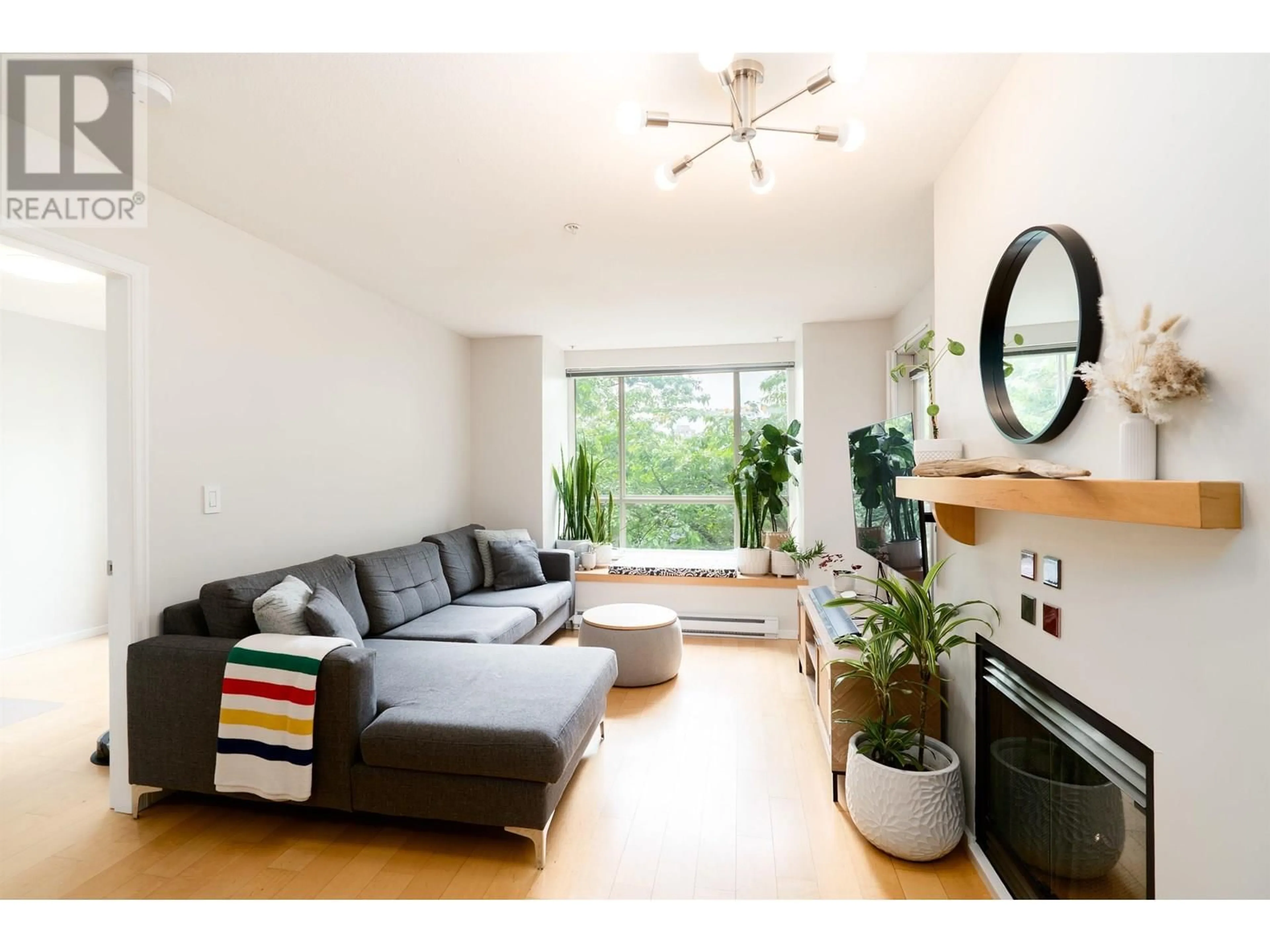 Living room with furniture, wood/laminate floor for 202 - 6833 VILLAGE, Burnaby British Columbia V5E4M1