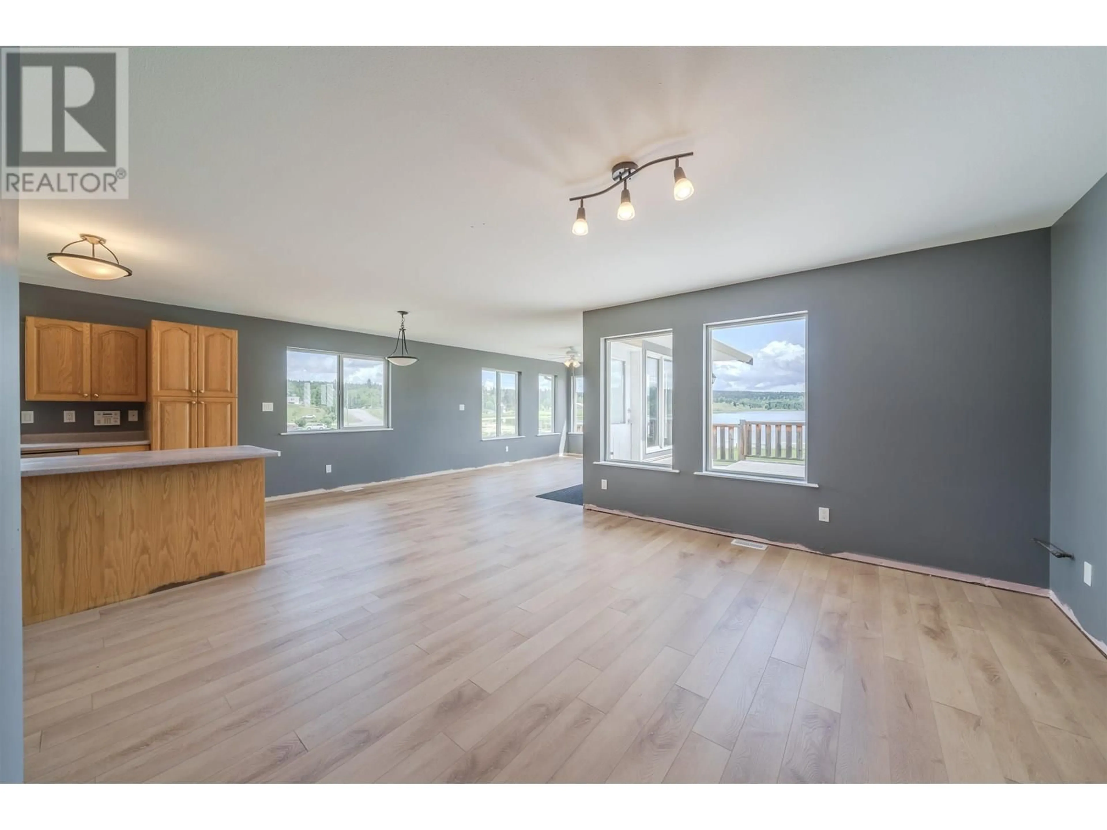 Open concept kitchen, wood/laminate floor for 5526 LAKESIDE COURT, 103 Mile House British Columbia V0K2E1