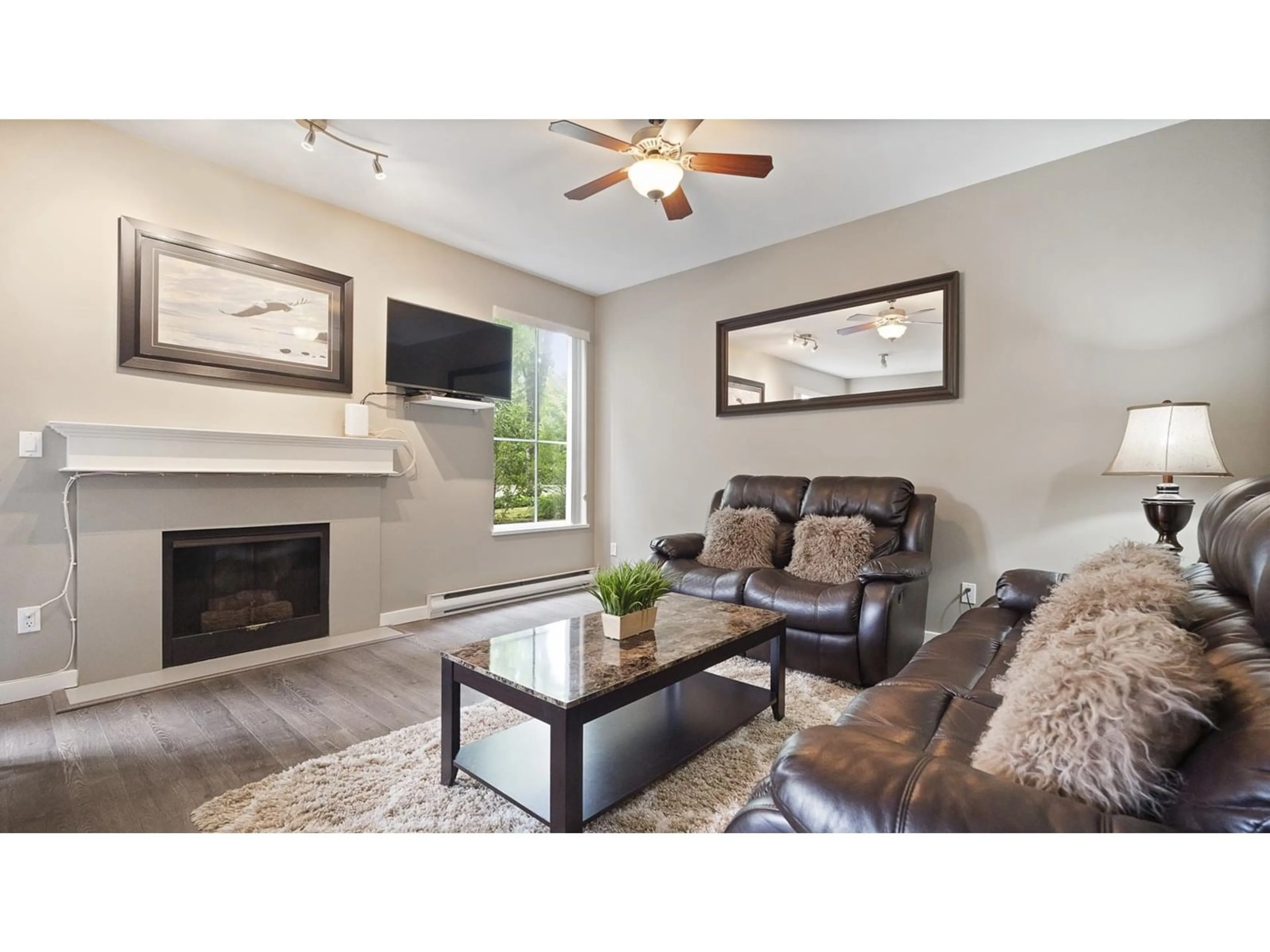 Living room with furniture, wood/laminate floor for 105 - 14998 101A, Surrey British Columbia V3R0T1