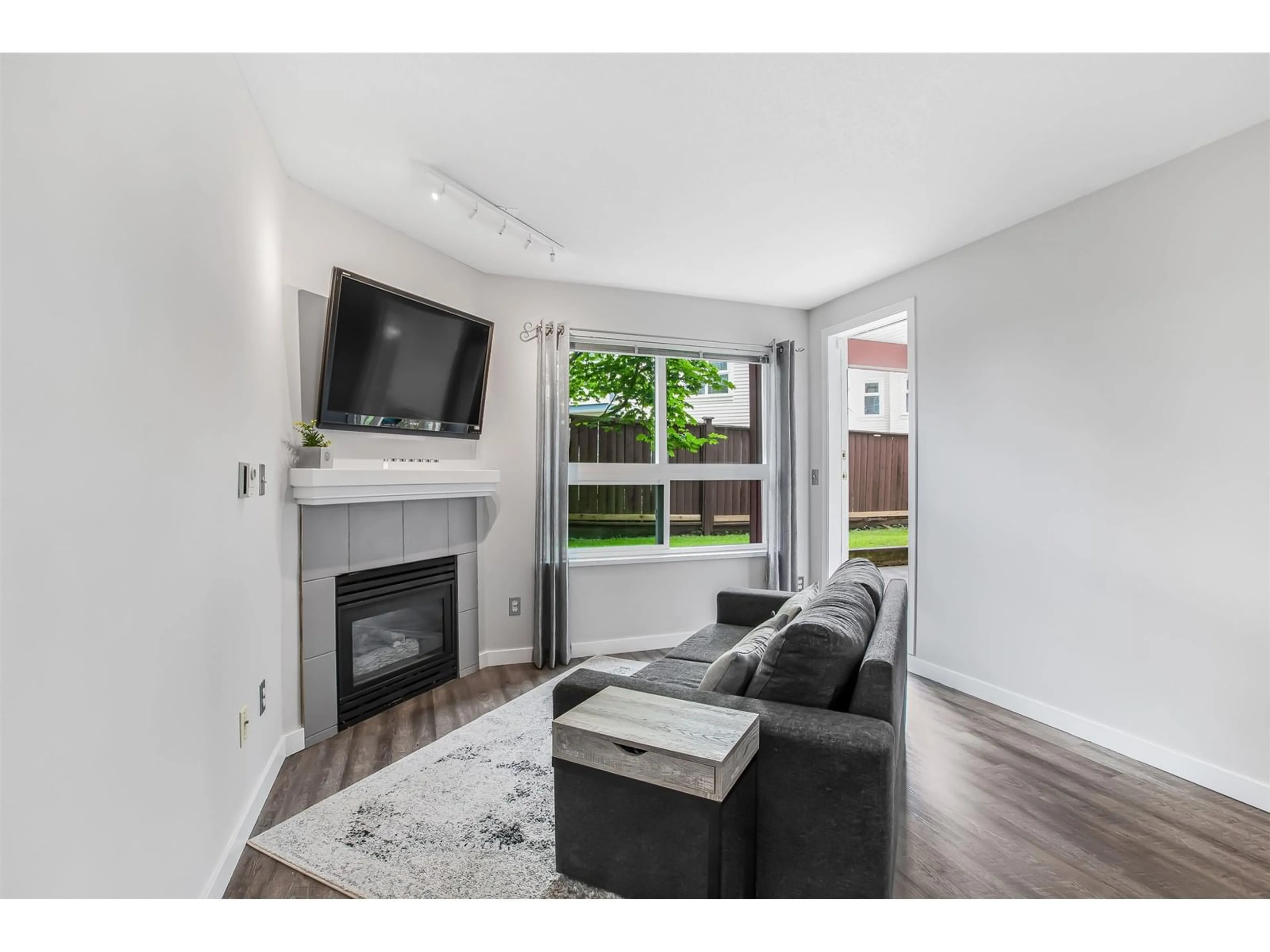 Living room with furniture, wood/laminate floor for 108 - 8068 120A, Surrey British Columbia V3W3P3