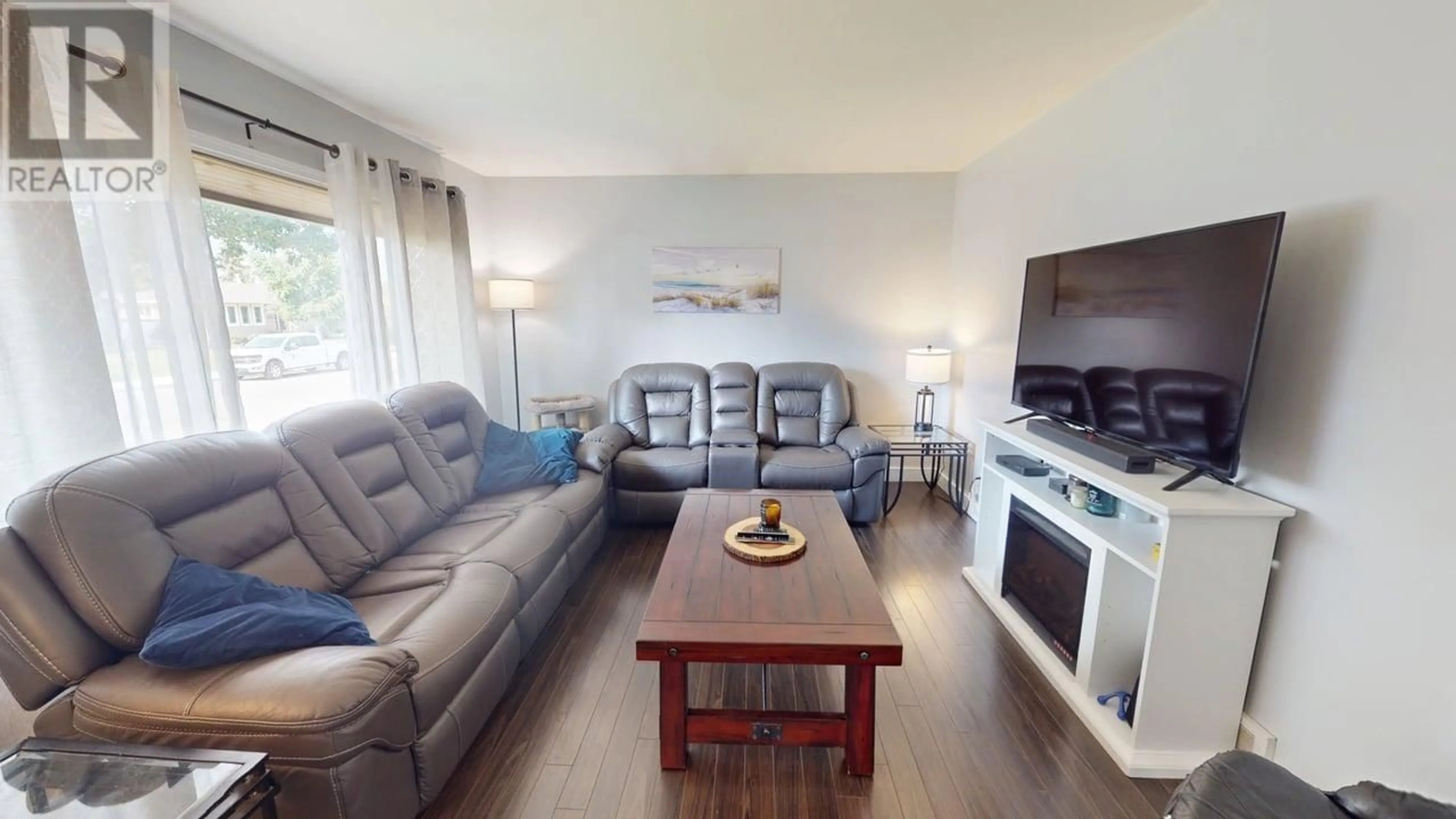 Living room with furniture, wood/laminate floor for 9316 111 AVENUE, Fort St. John British Columbia V1J2T7