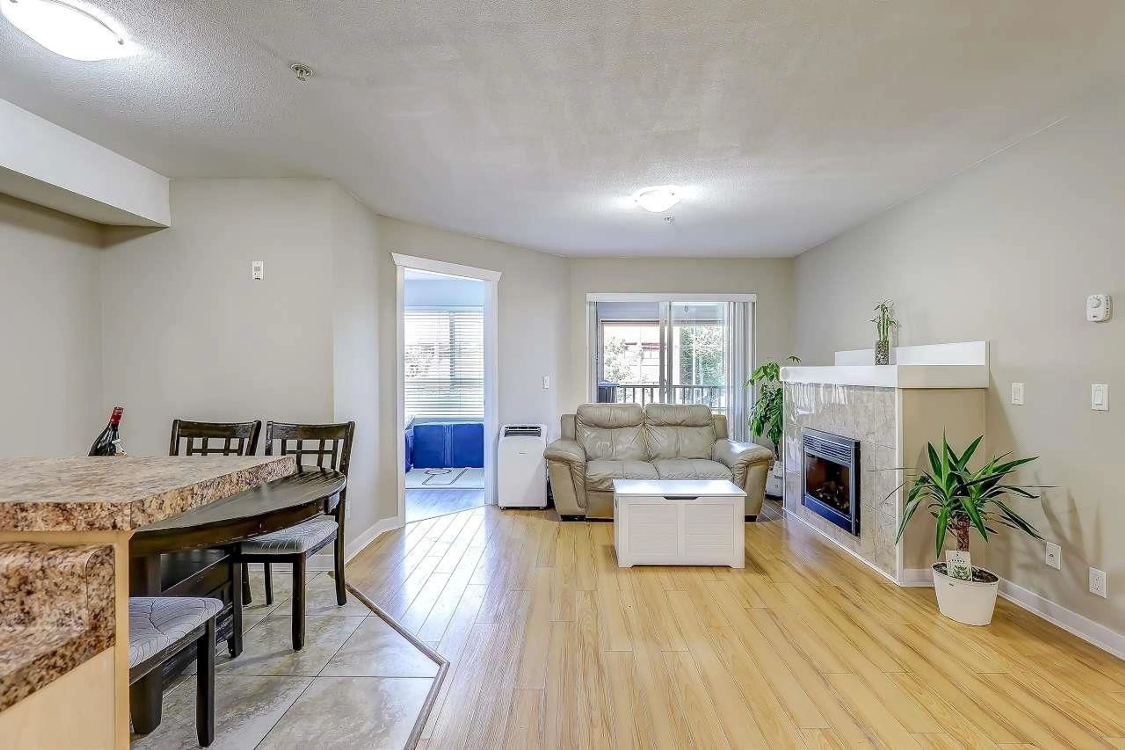 Living room with furniture, wood/laminate floor for 213 - 6960 120, Surrey British Columbia V3W1V4