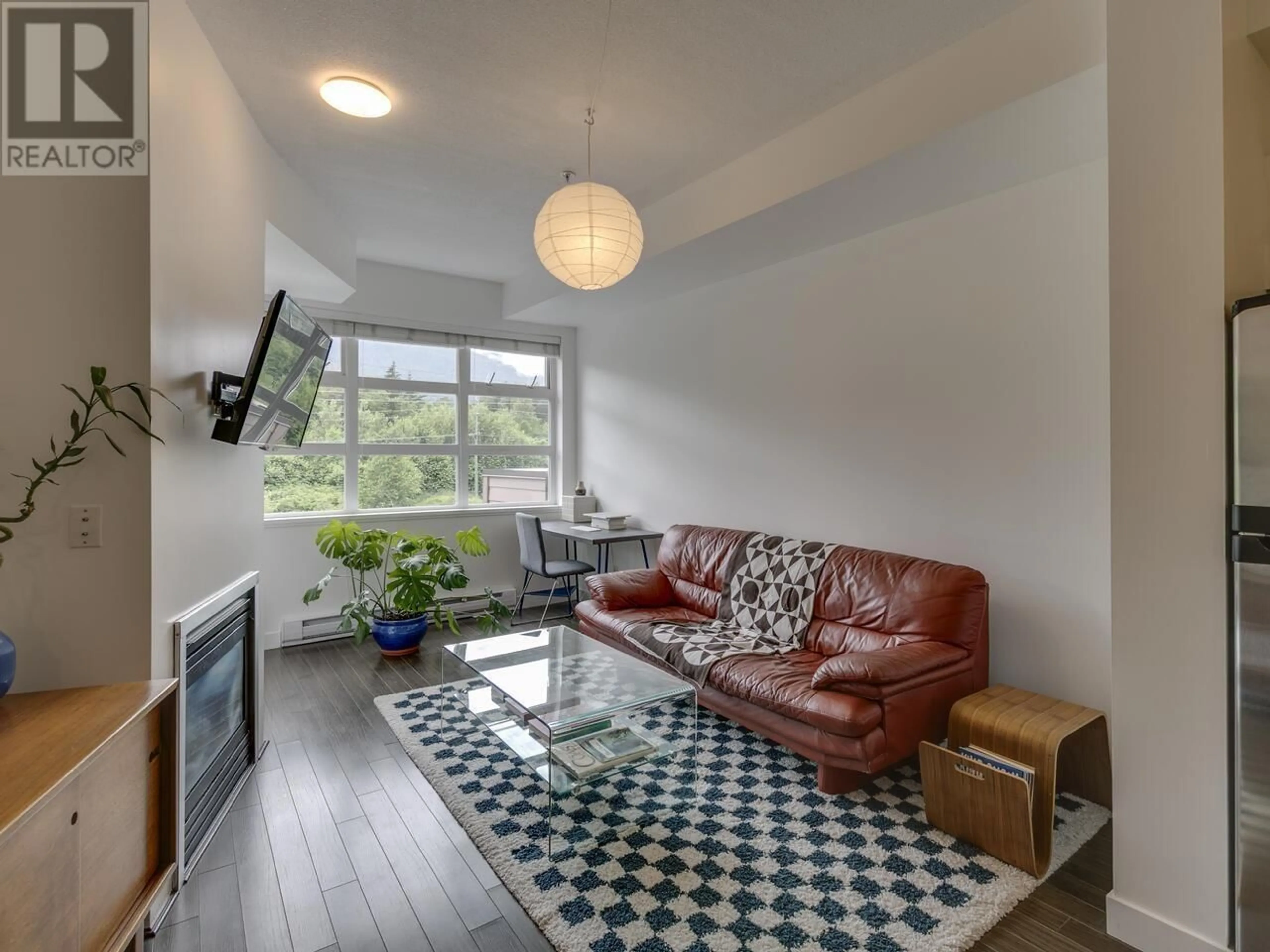 Living room with furniture, wood/laminate floor for 213 - 41105 TANTALUS ROAD, Squamish British Columbia V8B0N3