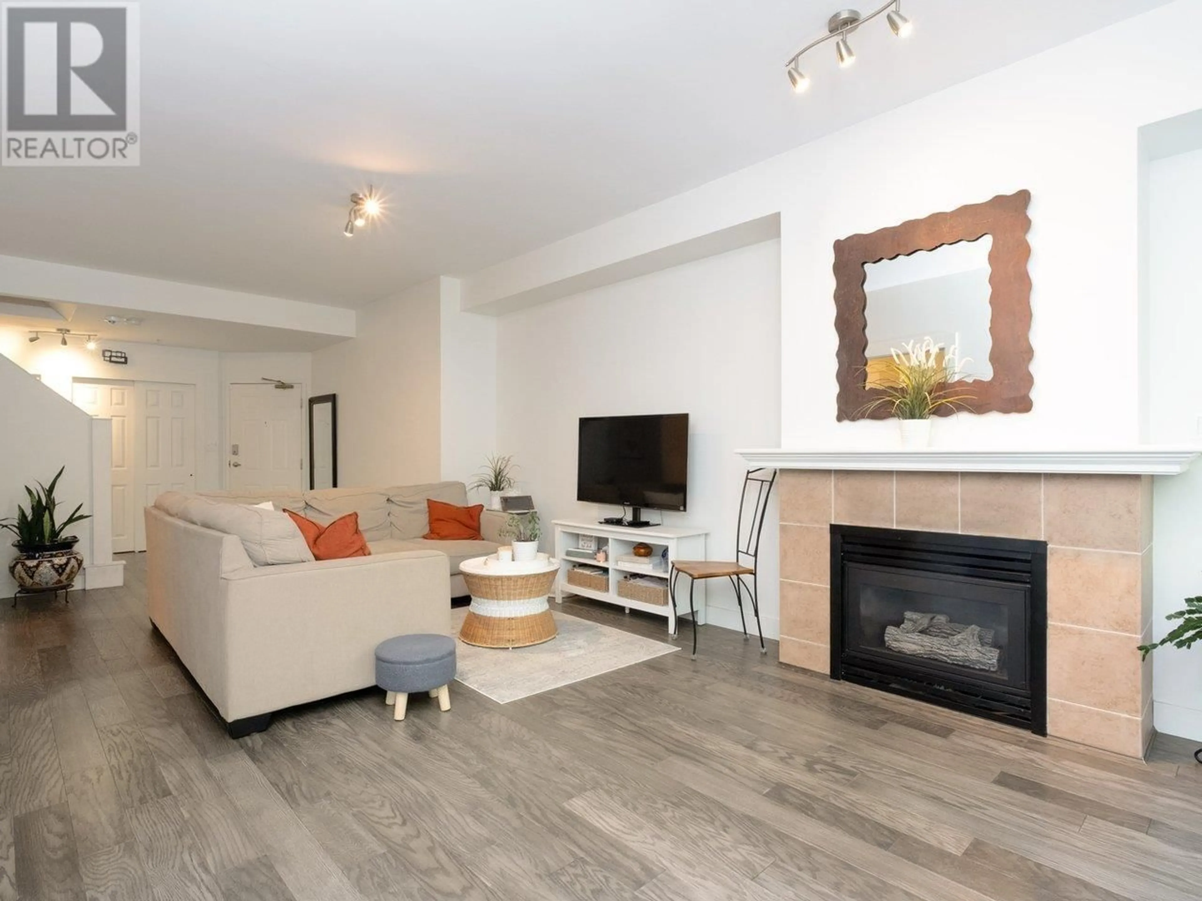 Living room with furniture, wood/laminate floor for 204 - 3600 WINDCREST DRIVE, North Vancouver British Columbia V7G2S5