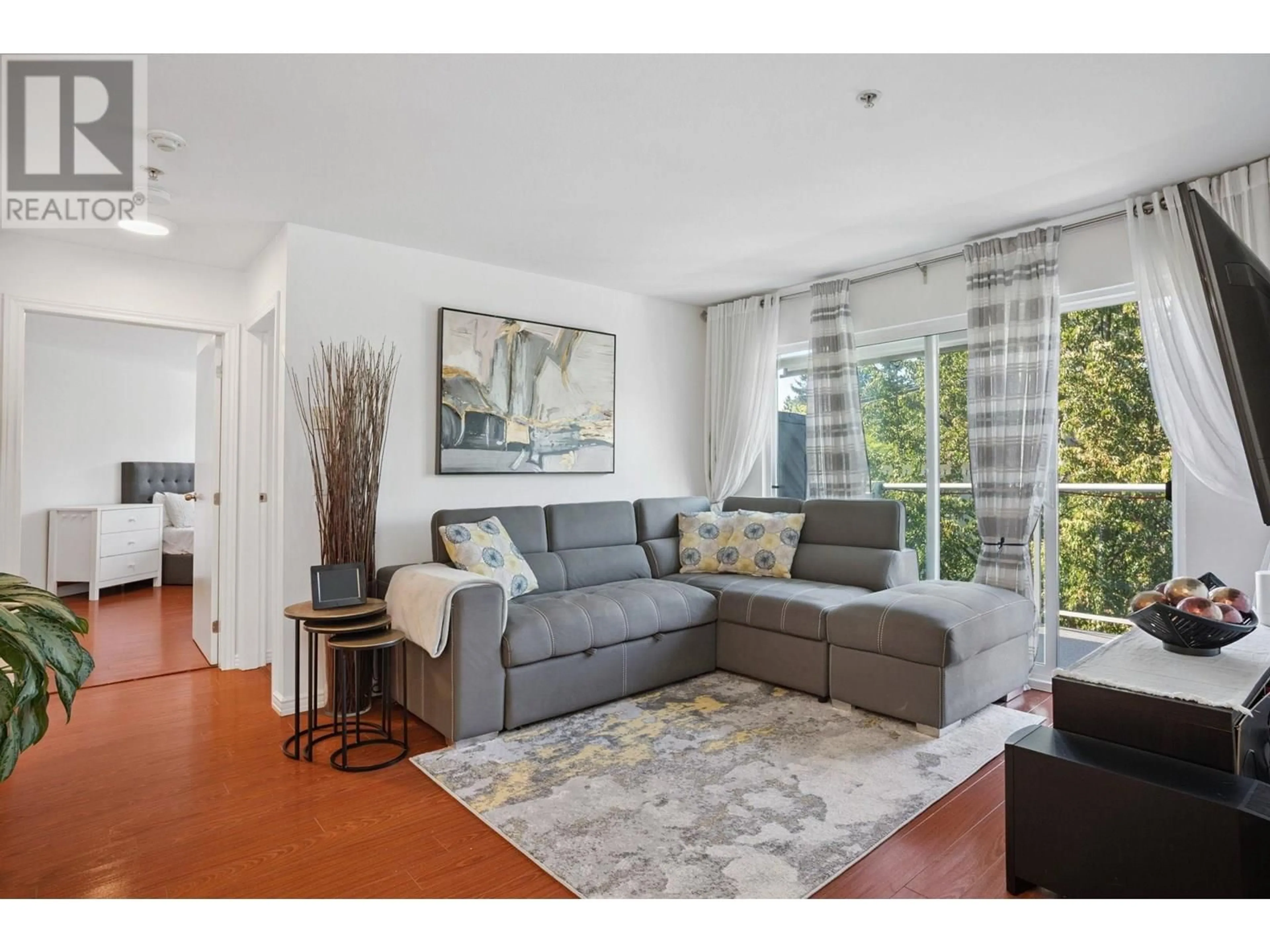 Living room with furniture, wood/laminate floor for 402 - 2983 CAMBRIDGE STREET, Port Coquitlam British Columbia V3B7N7