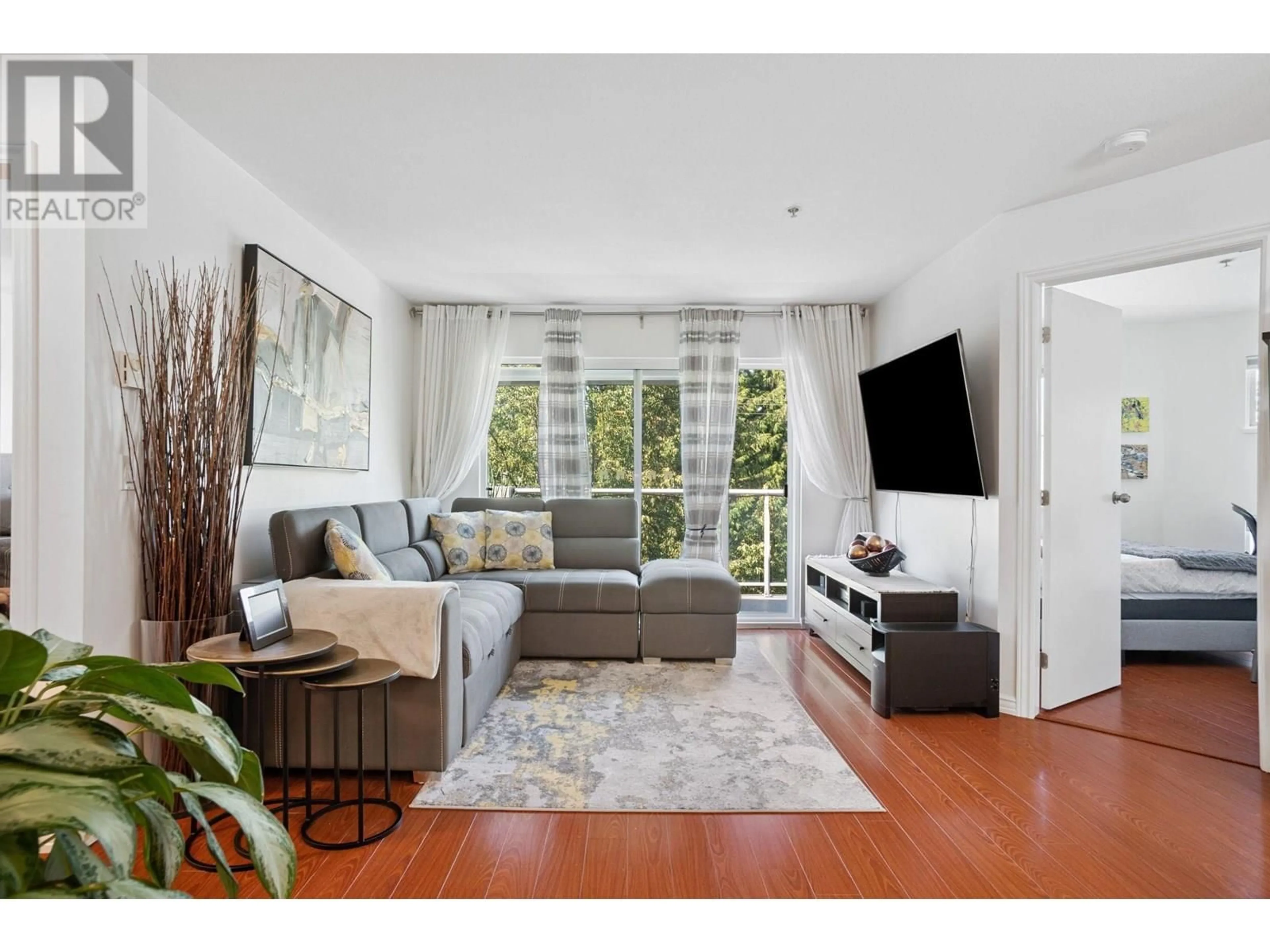 Living room with furniture, wood/laminate floor for 402 - 2983 CAMBRIDGE STREET, Port Coquitlam British Columbia V3B7N7