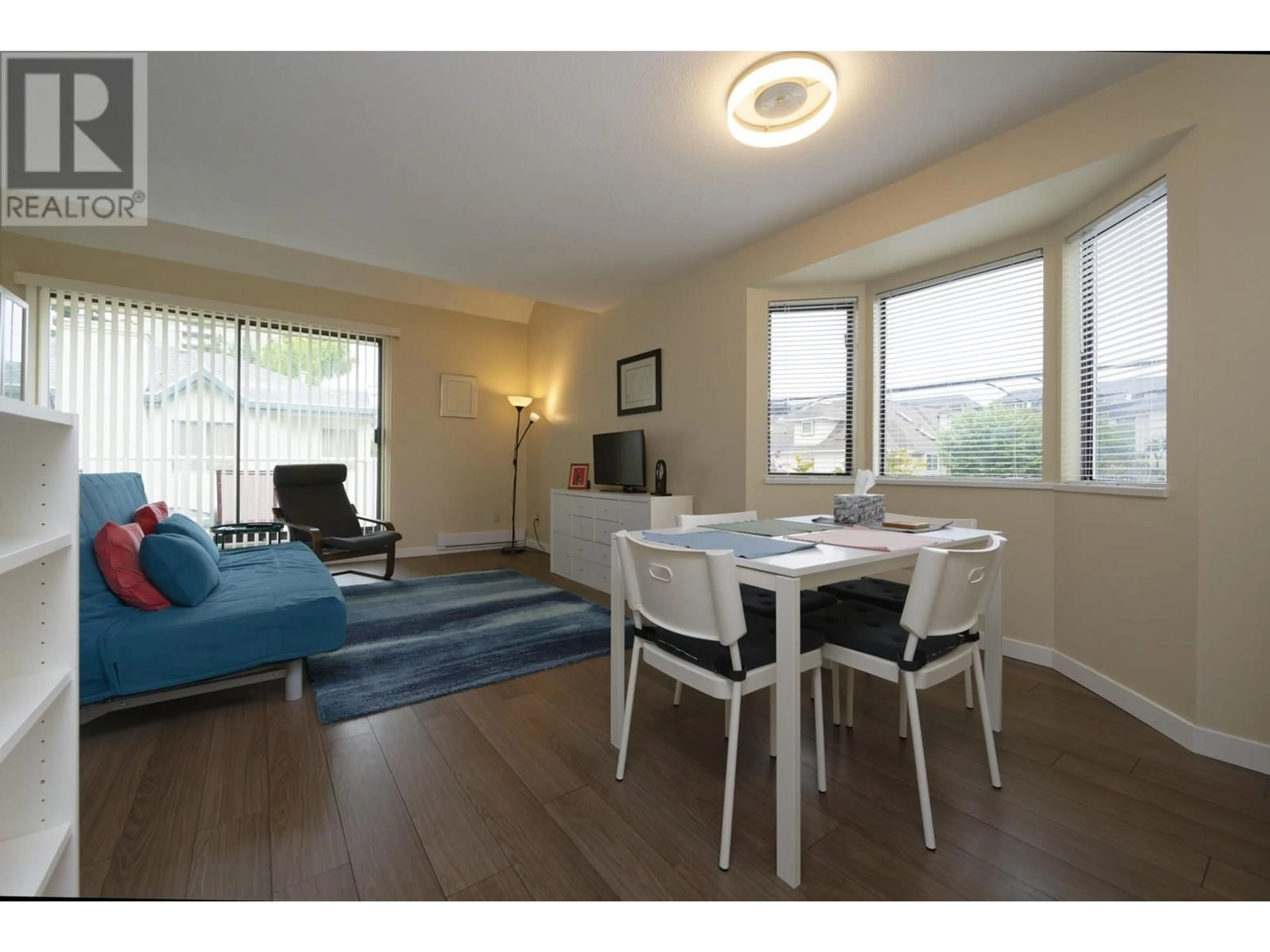 Living room with furniture, wood/laminate floor for 1 - 6431 COONEY ROAD, Richmond British Columbia V6Y2J5