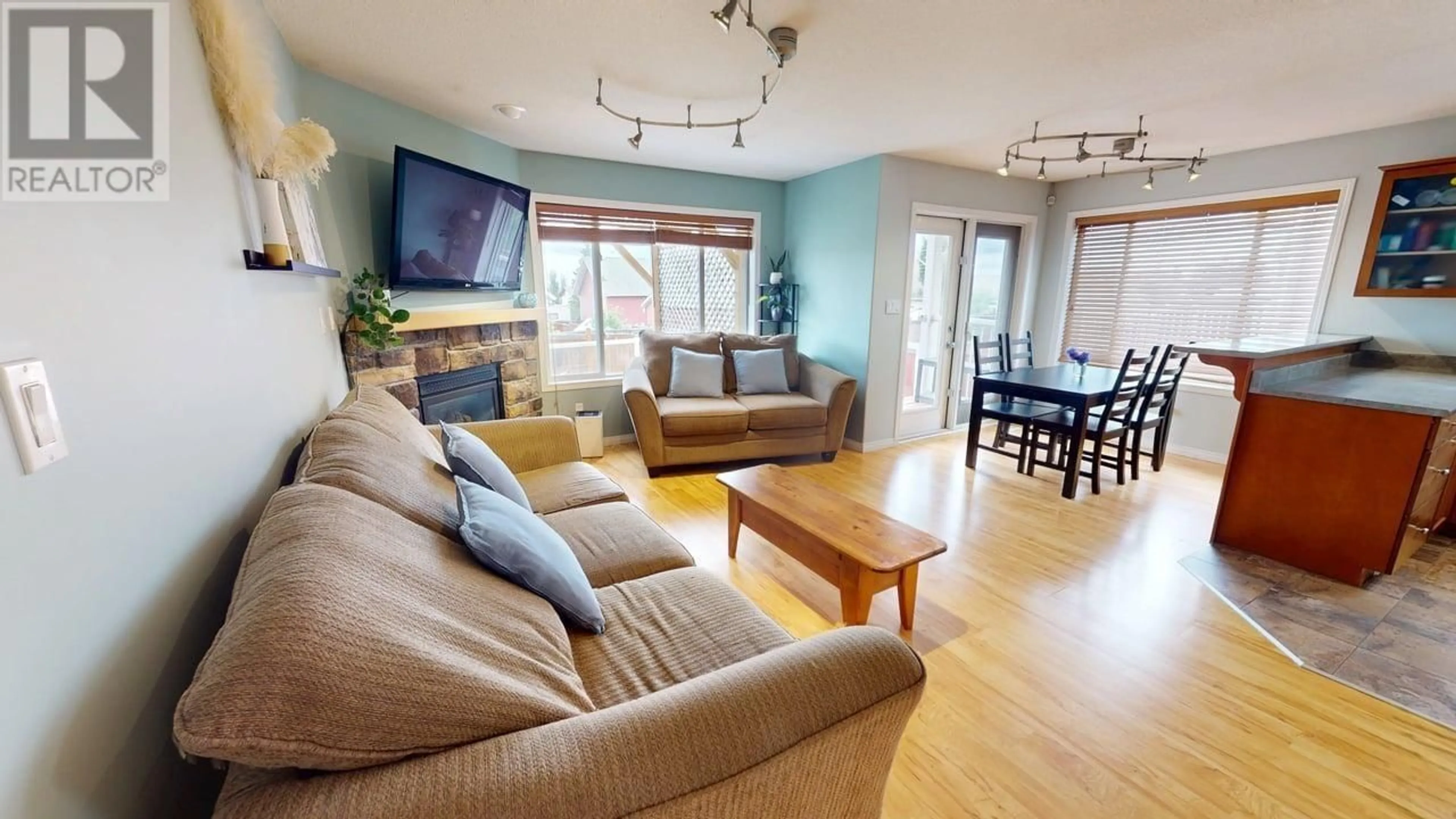 Living room with furniture, wood/laminate floor for 8716 114 AVENUE, Fort St. John British Columbia V1J0C3