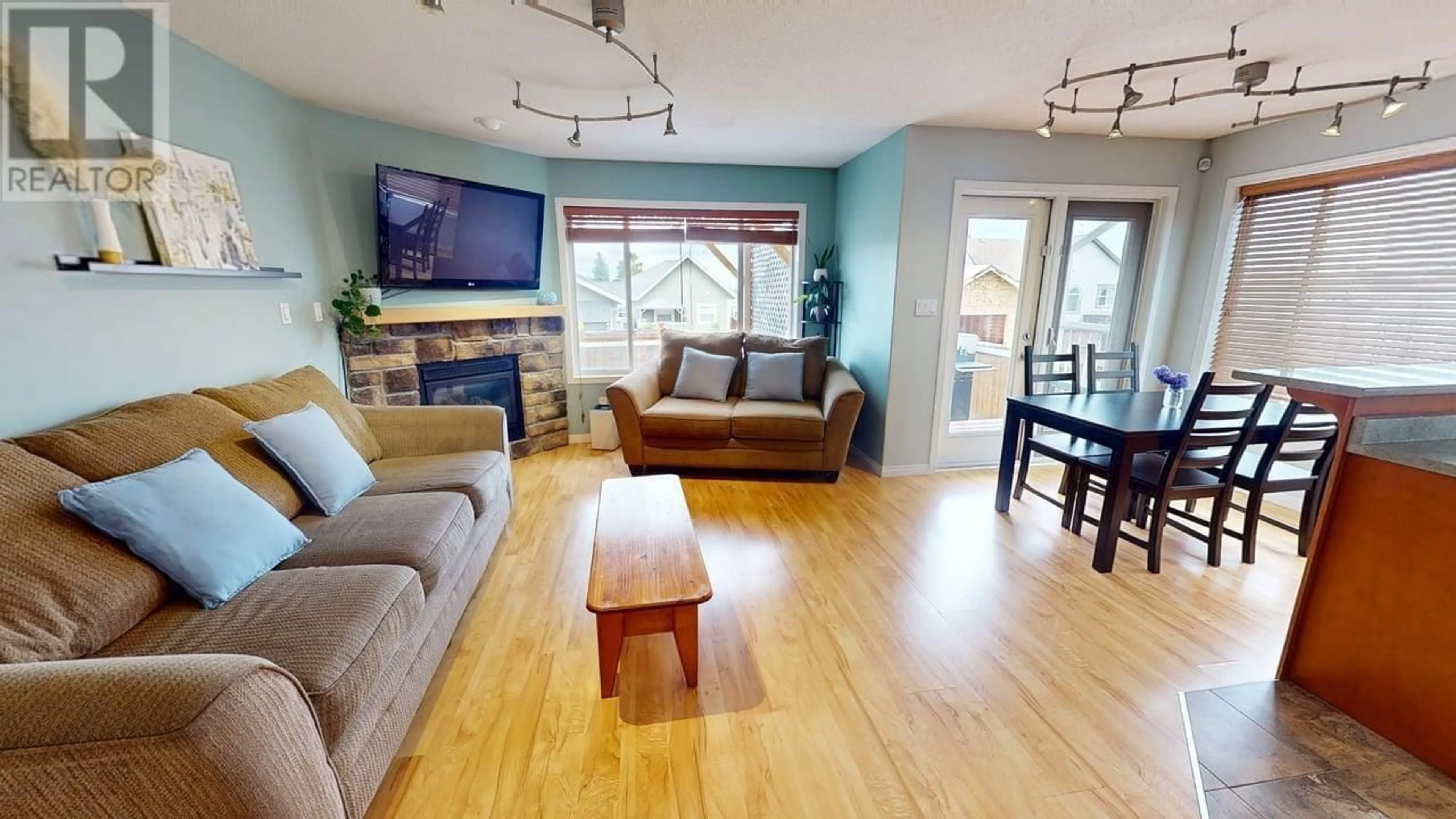 Living room with furniture, wood/laminate floor for 8716 114 AVENUE, Fort St. John British Columbia V1J0C3