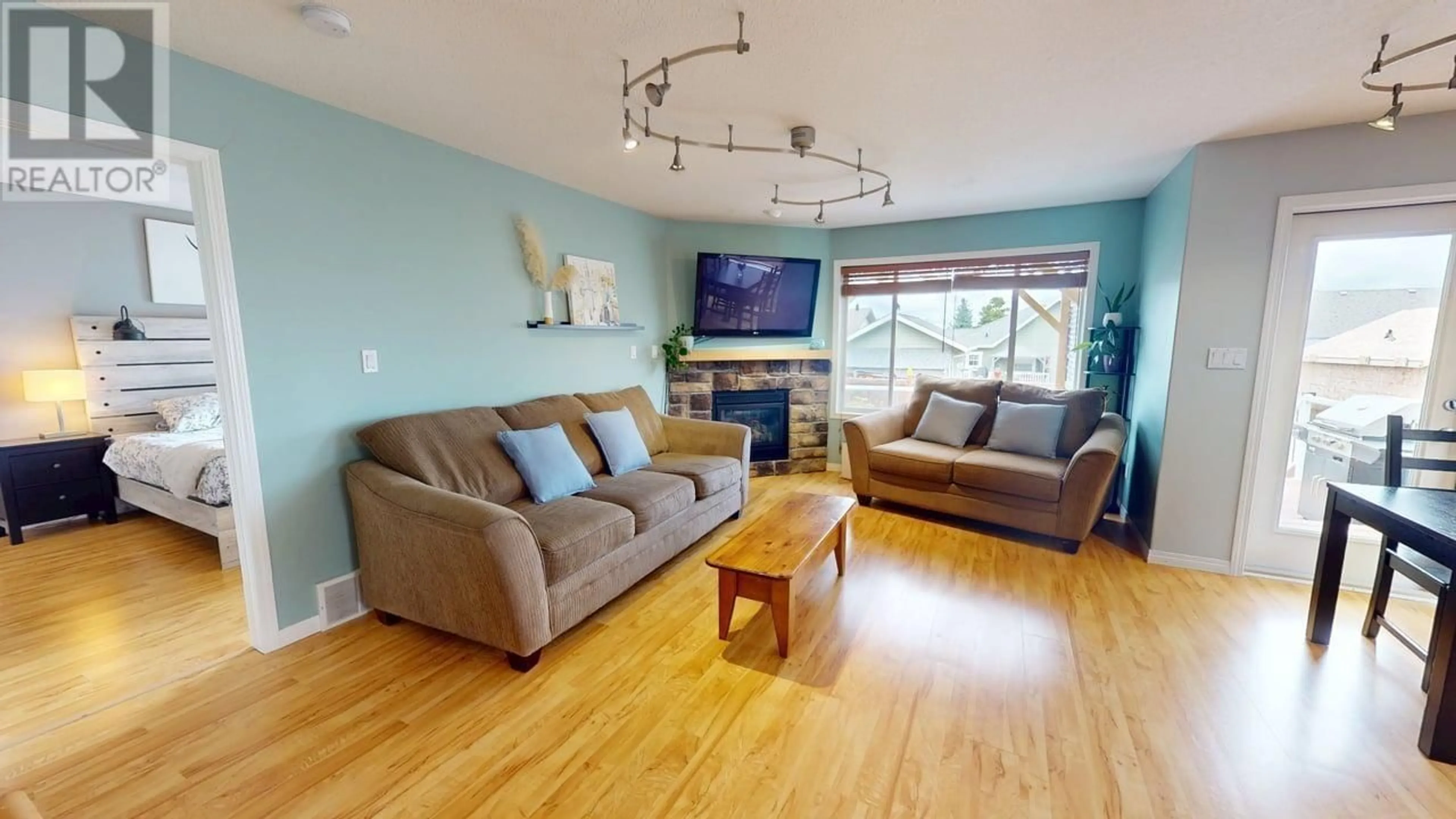 Living room with furniture, wood/laminate floor for 8716 114 AVENUE, Fort St. John British Columbia V1J0C3